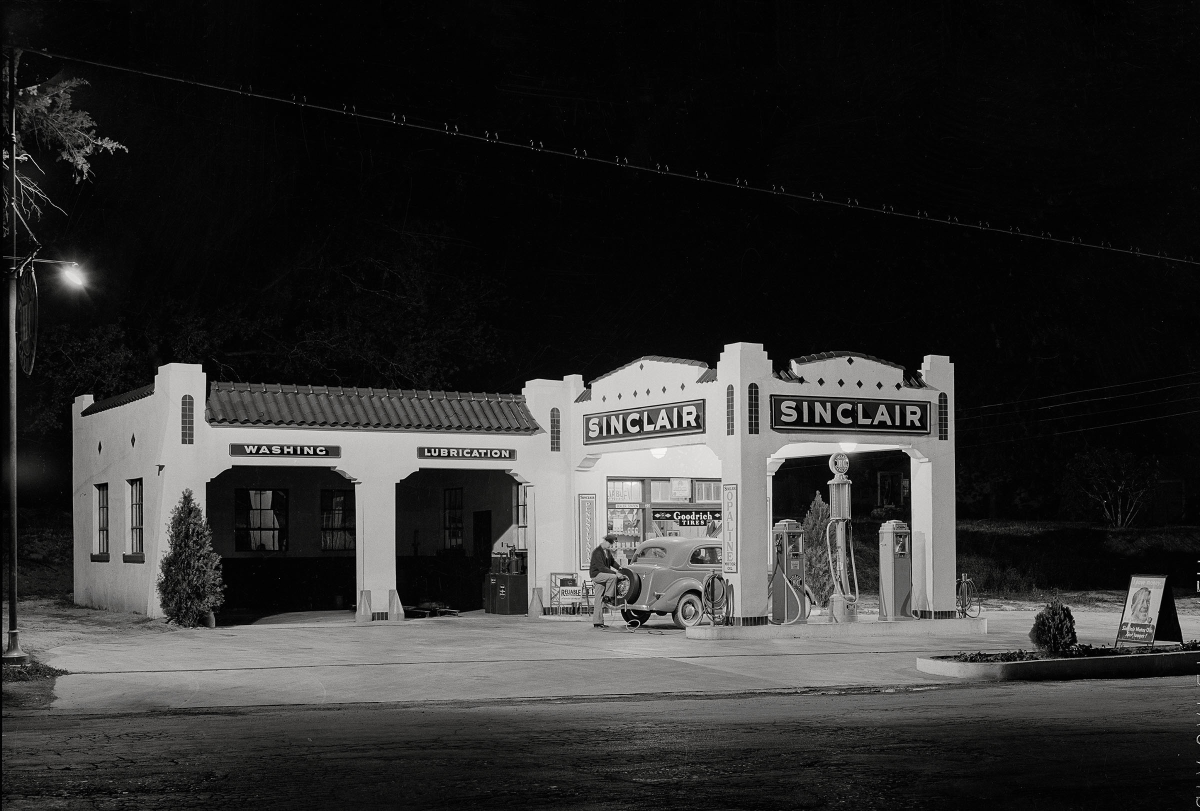Vintage photo of a Sinclair Station with a man pumping gas