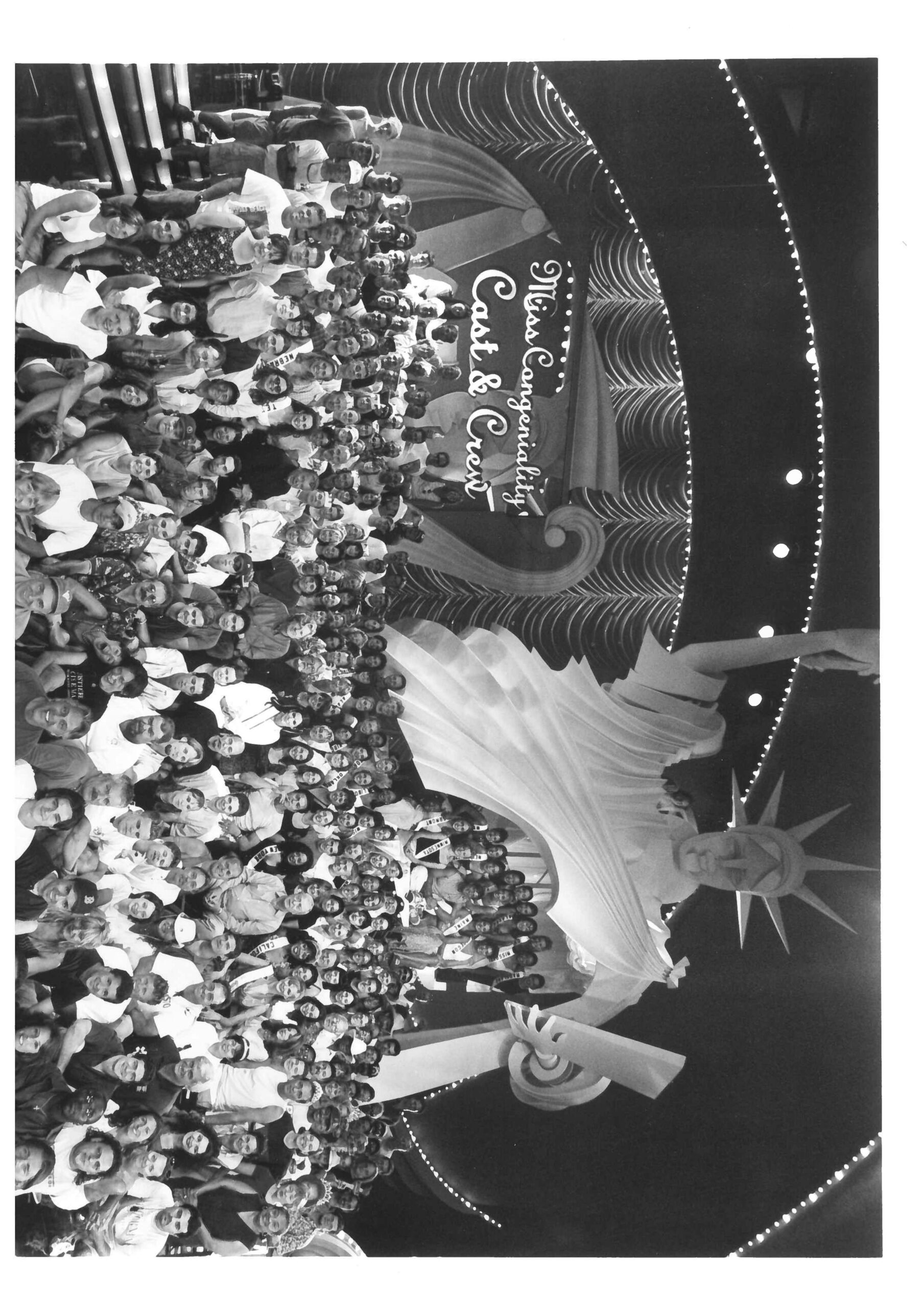 cast and crew of miss congeniality gathered on stage for a photo with lady liberty