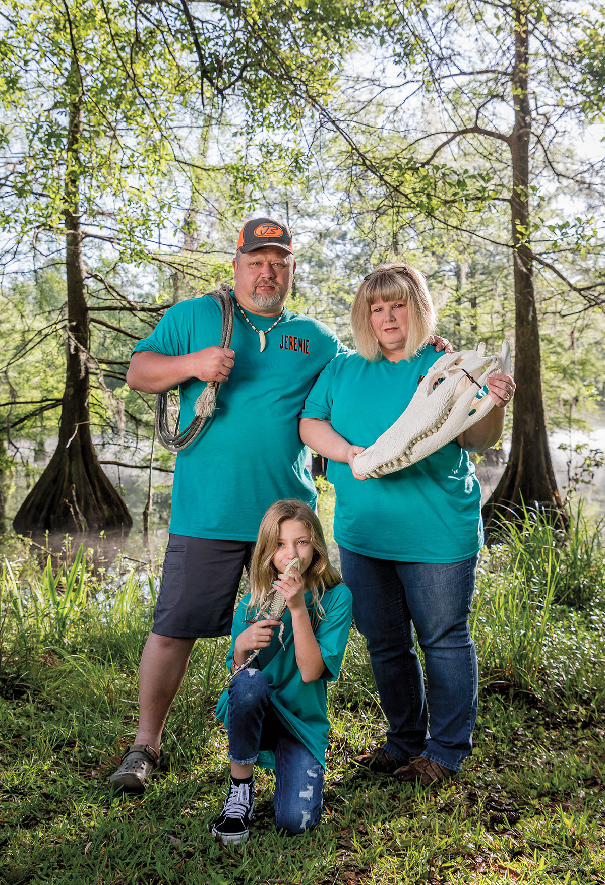 Jeremie Estillette, a certified alligator rescue professional, poses with his wife, Kim, and daughter, Kallie, along with some alligator paraphernalia