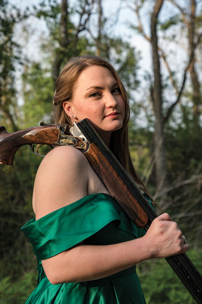Holly Hearne poses with a gun draped over her shoulder