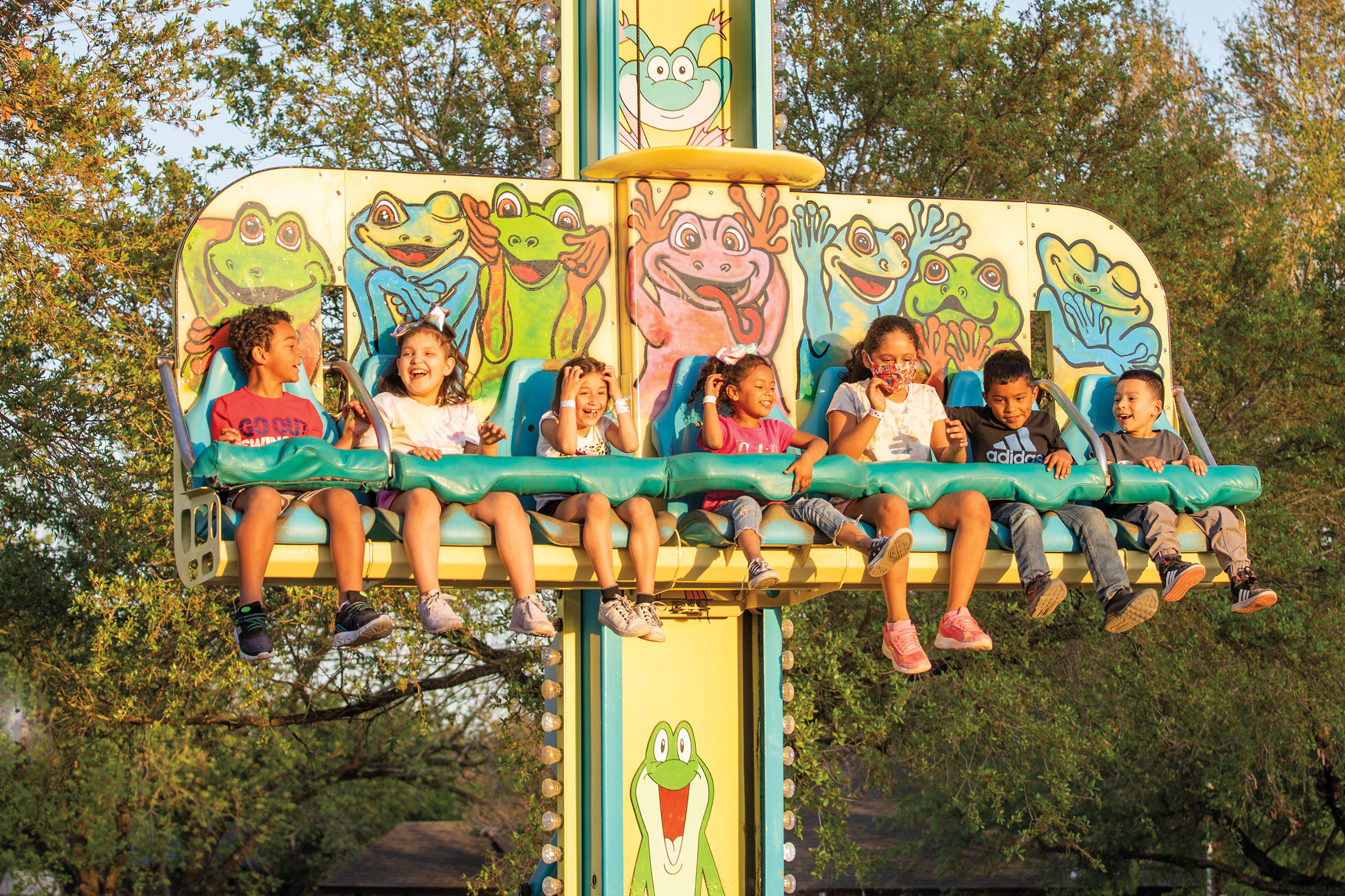 A group of people on a frog-themed ride