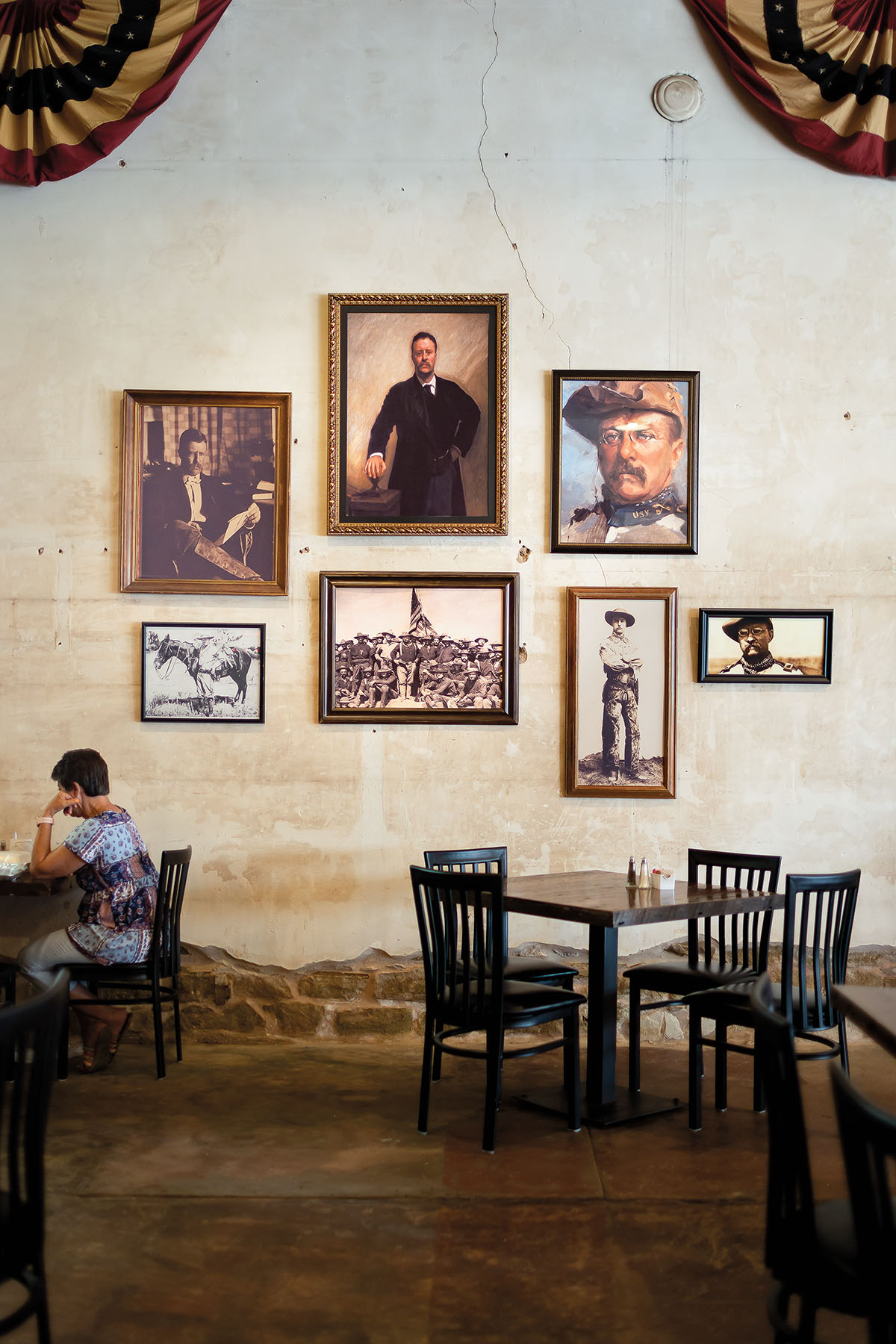 Framed pictures hang above dark wood furniture