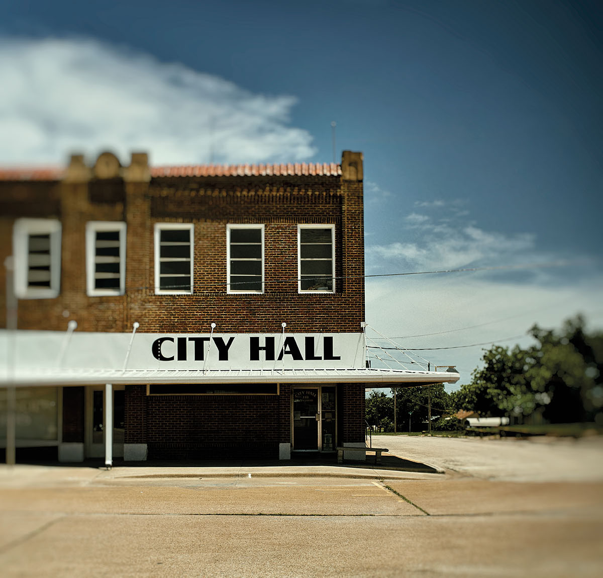 An old brick building on a concrete slab reading "City Hall"