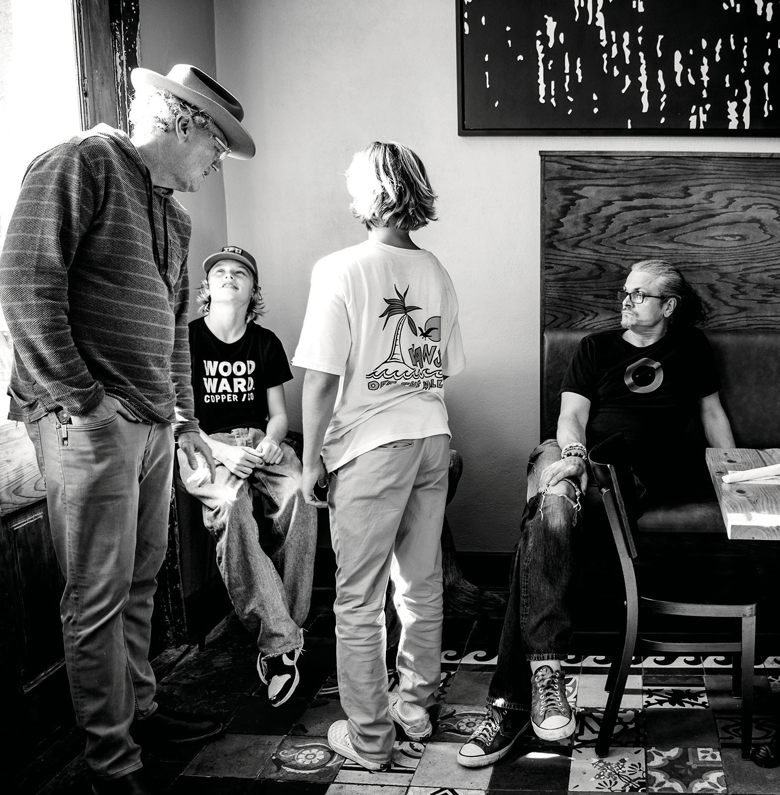 A group of people stand by a window waiting for a table