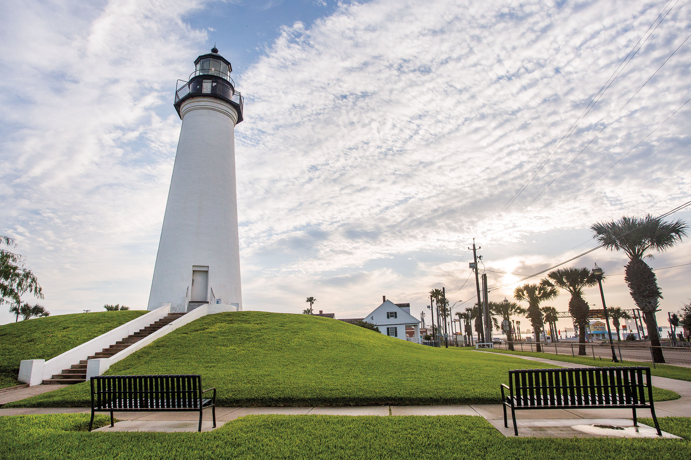 A white lighthouse above bright green grass