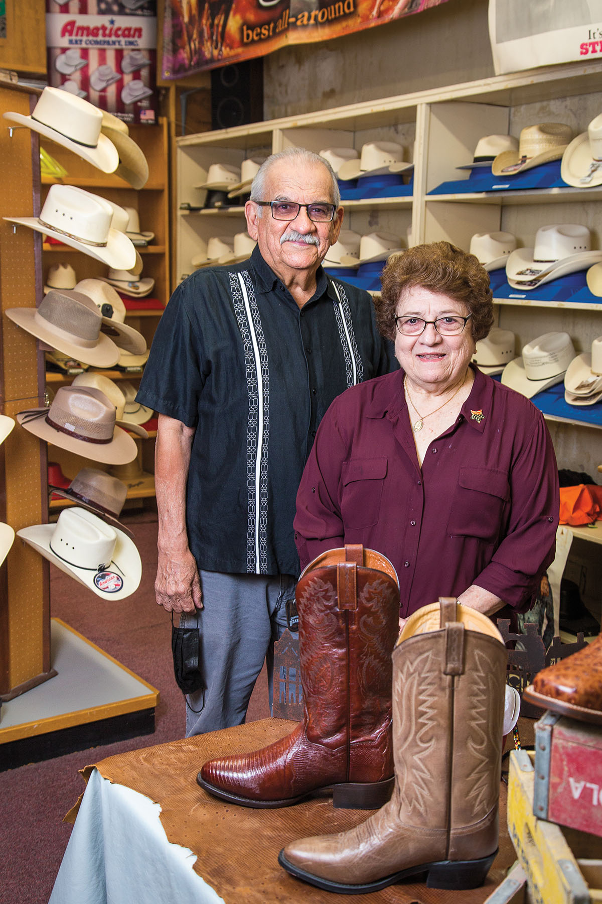 A man and woman stand in a hat store