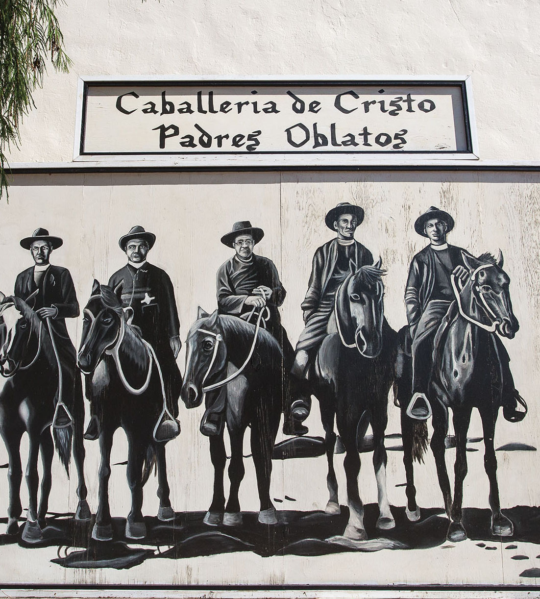 A black and white painted mural of men on horseback