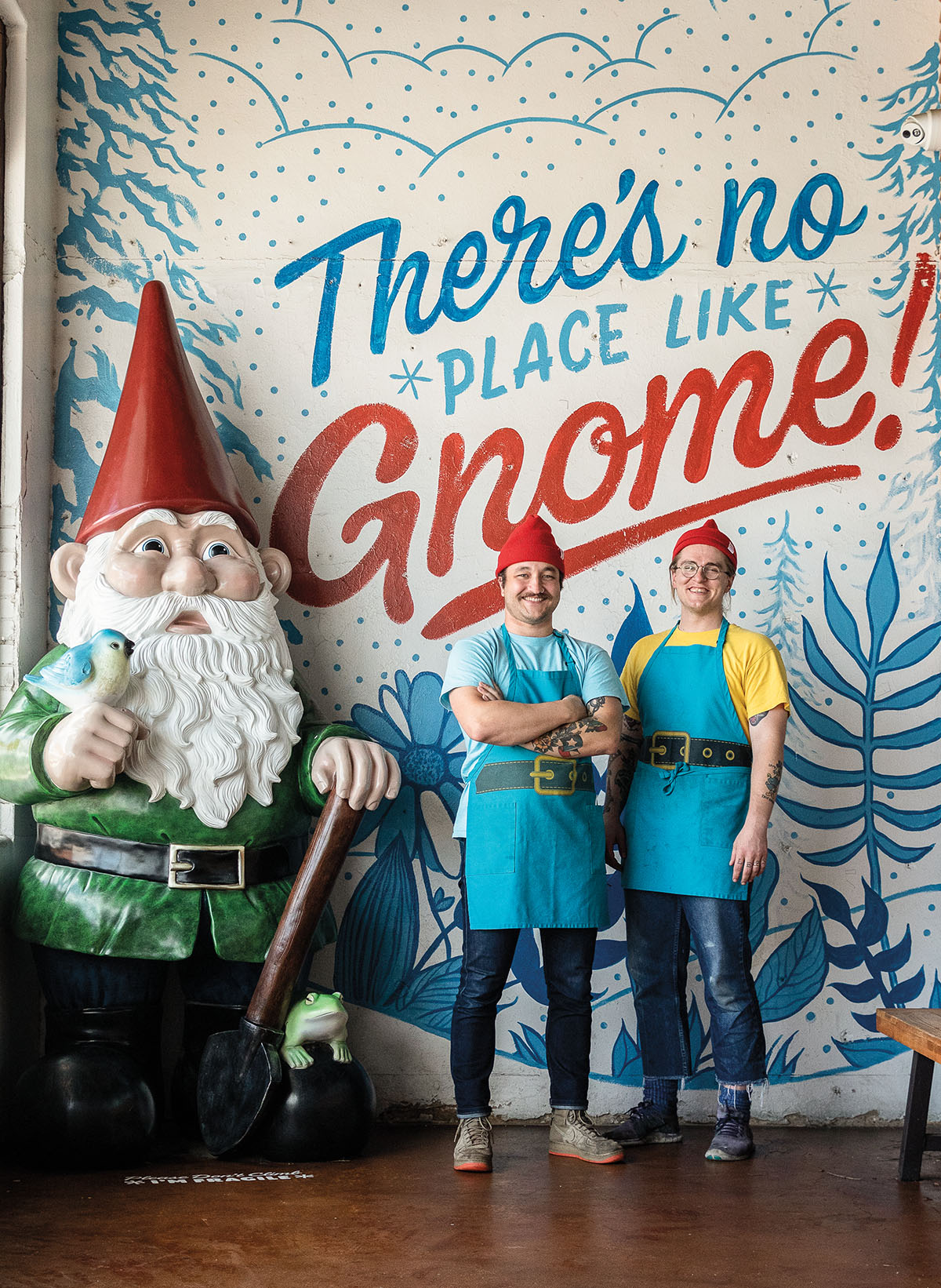 Owners Bret Hawkins (left) and Alex Sparks stand next to a giant gnome at their downtown Denton location.