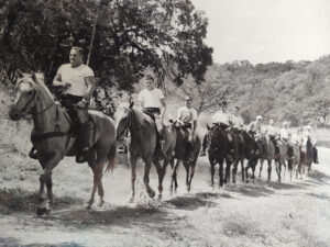 Boys horseback riding at camp.