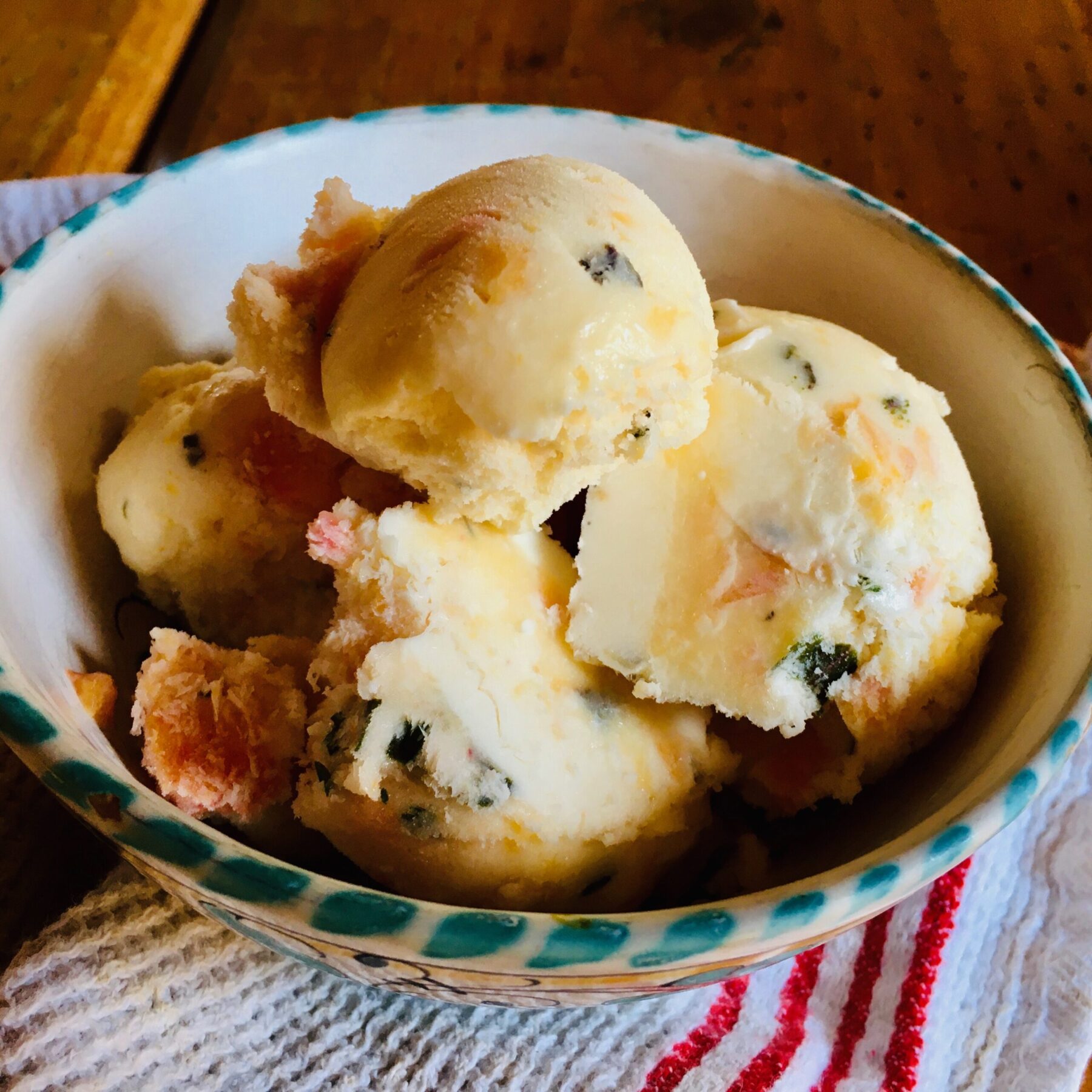 peach and basil ice cream in a bowl on a countertop