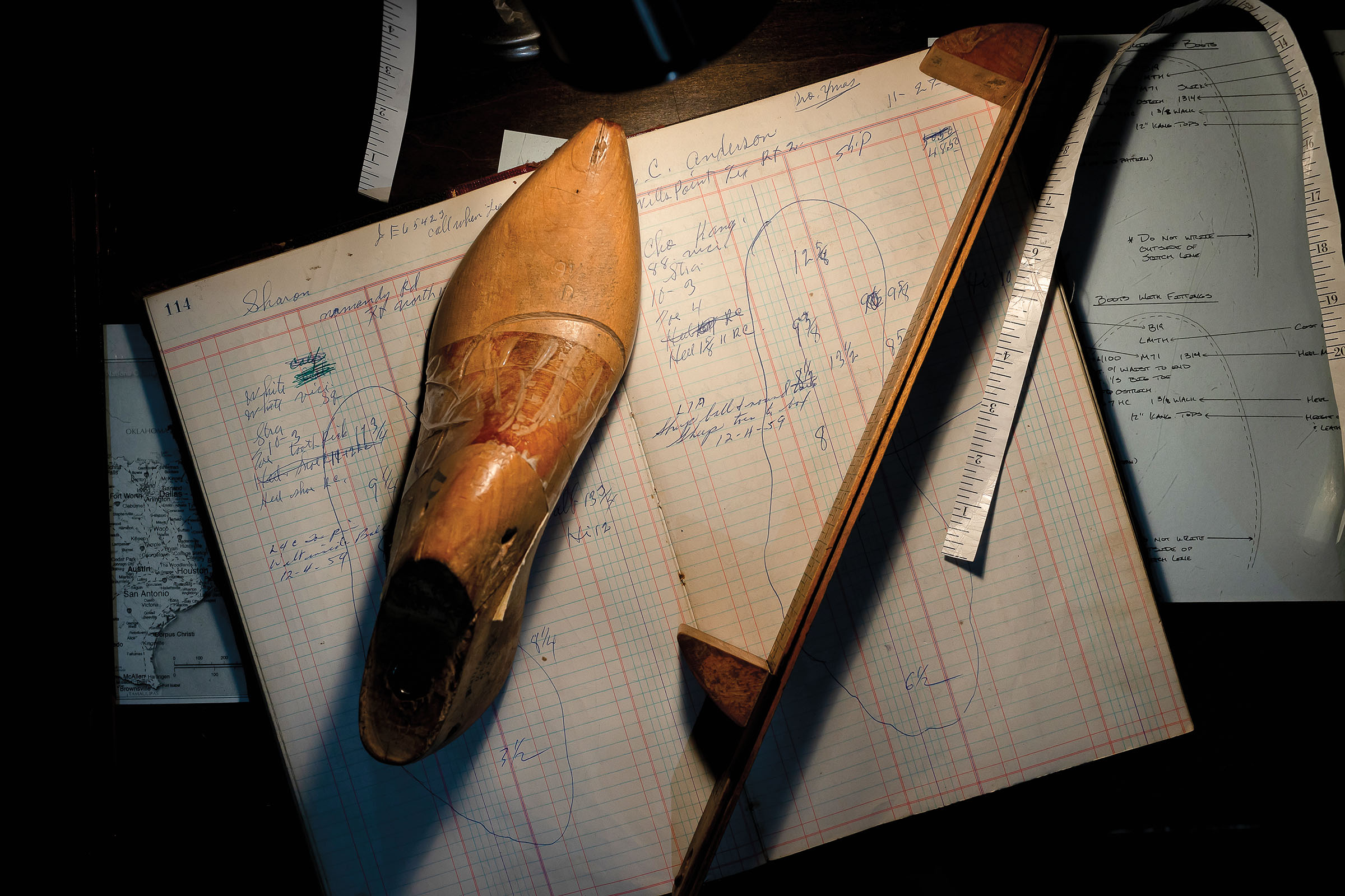 An overhead view of a tan boot, measuring device and graph paper