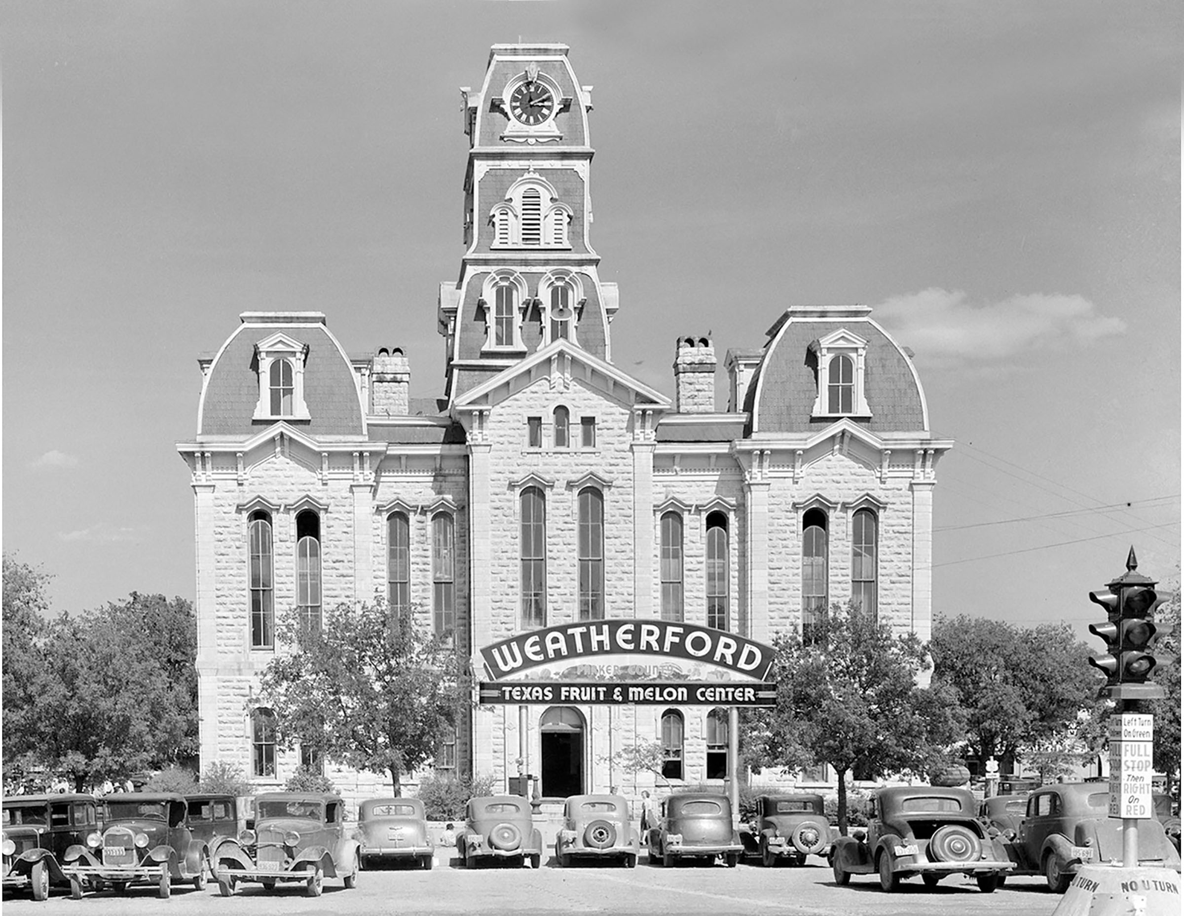 A tall white building with a sign reading 'Weatherford Texas Fruit & Melon Center'