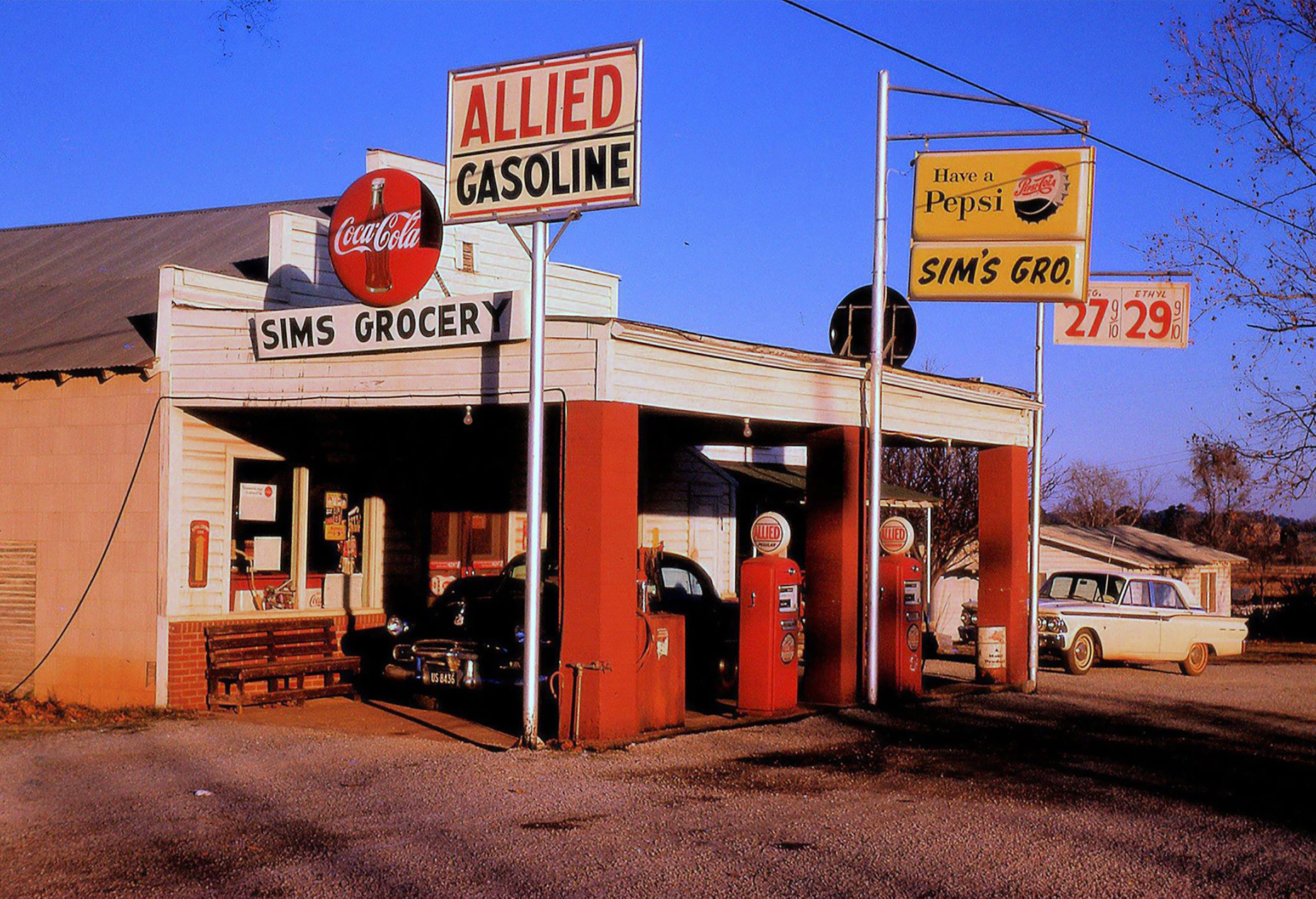 Bright red and white fuel pumps under a sign reading 'Allied Gasoline'