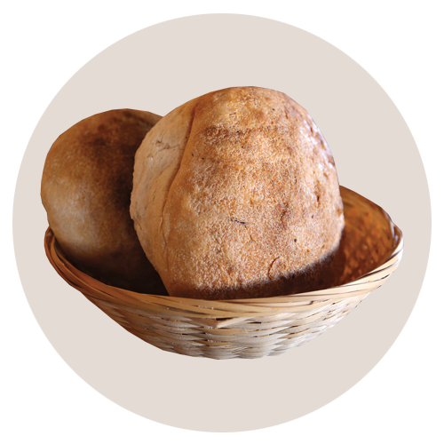 Two round loaves of bread in a small wicker basket