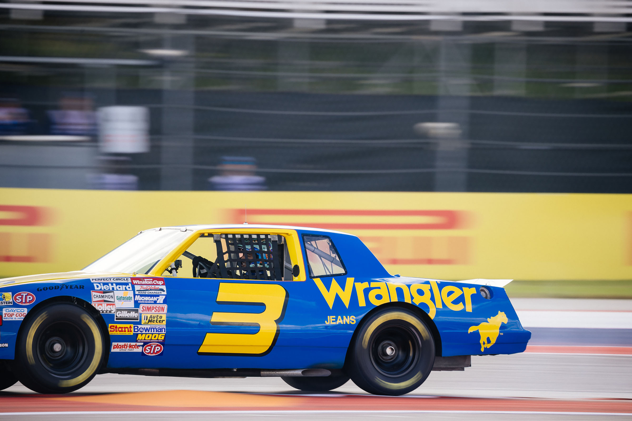 A blue and yellow painted car with the name 'Wrangler' on the side