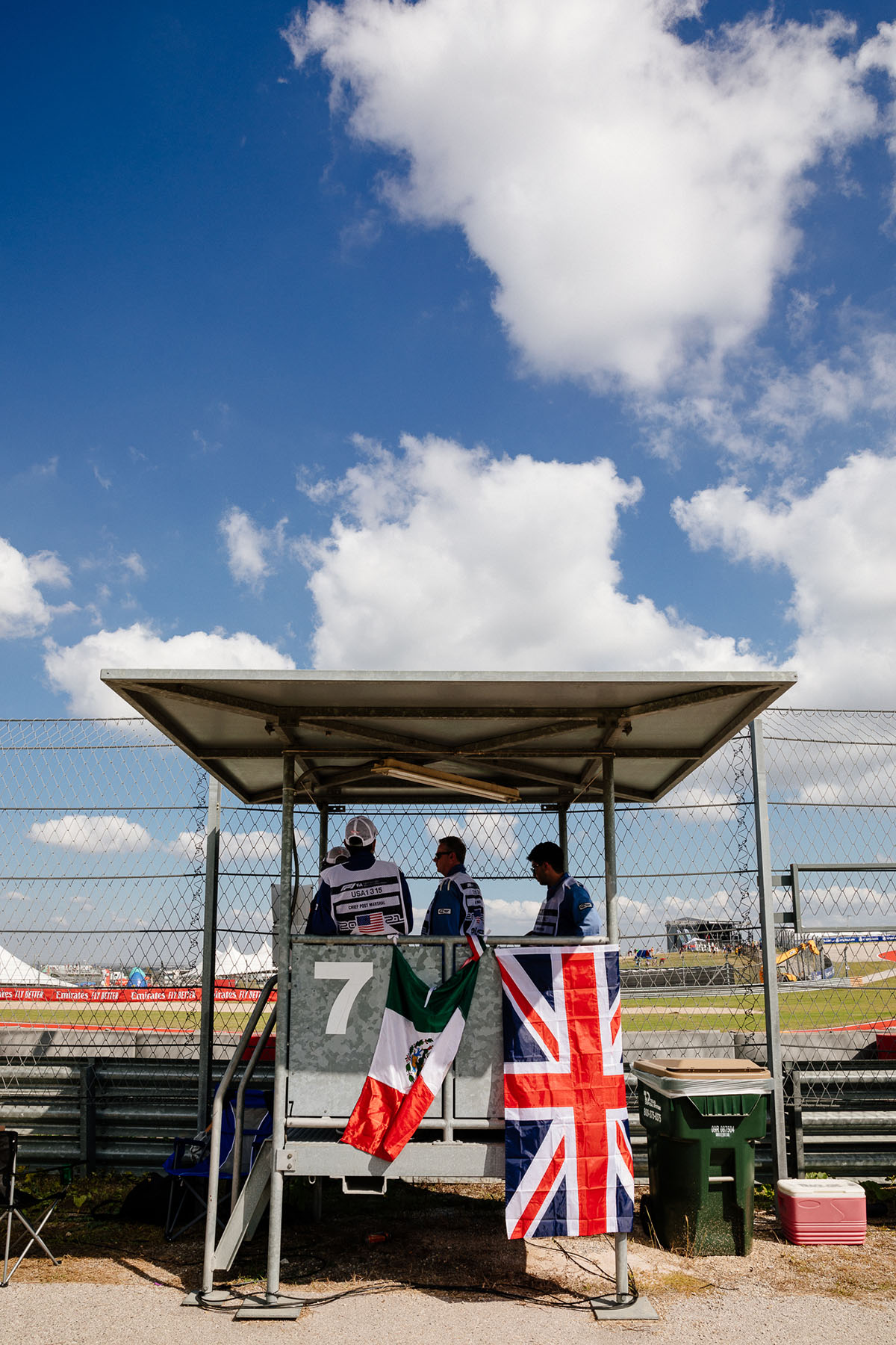 A British and Mexican flag hang from a shaded stand outside of a racetrack