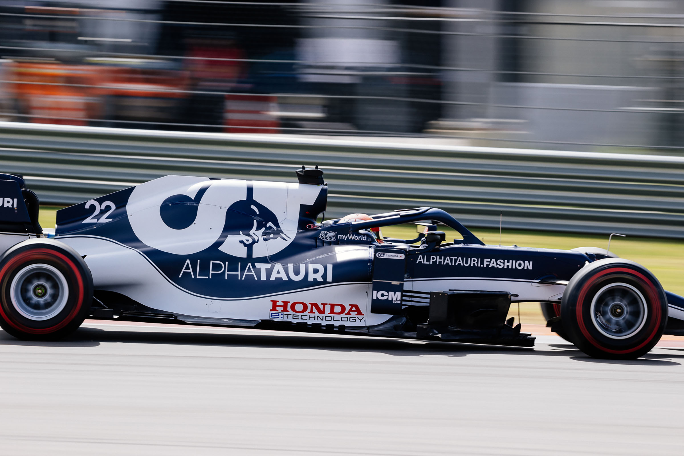The side of a blue and white painted car reading 'Alpha Tauri'