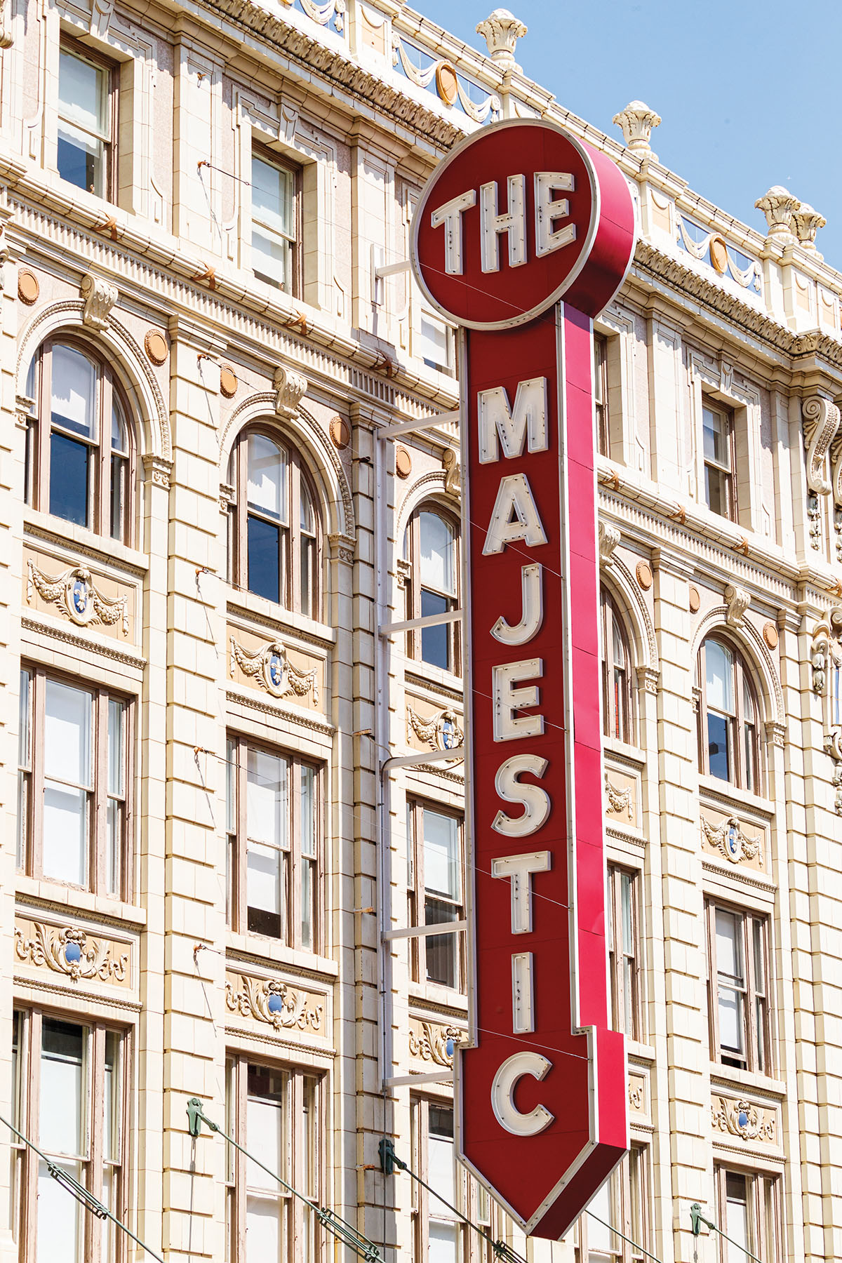 The outside of a theater with a red sign reading "The Magestic"