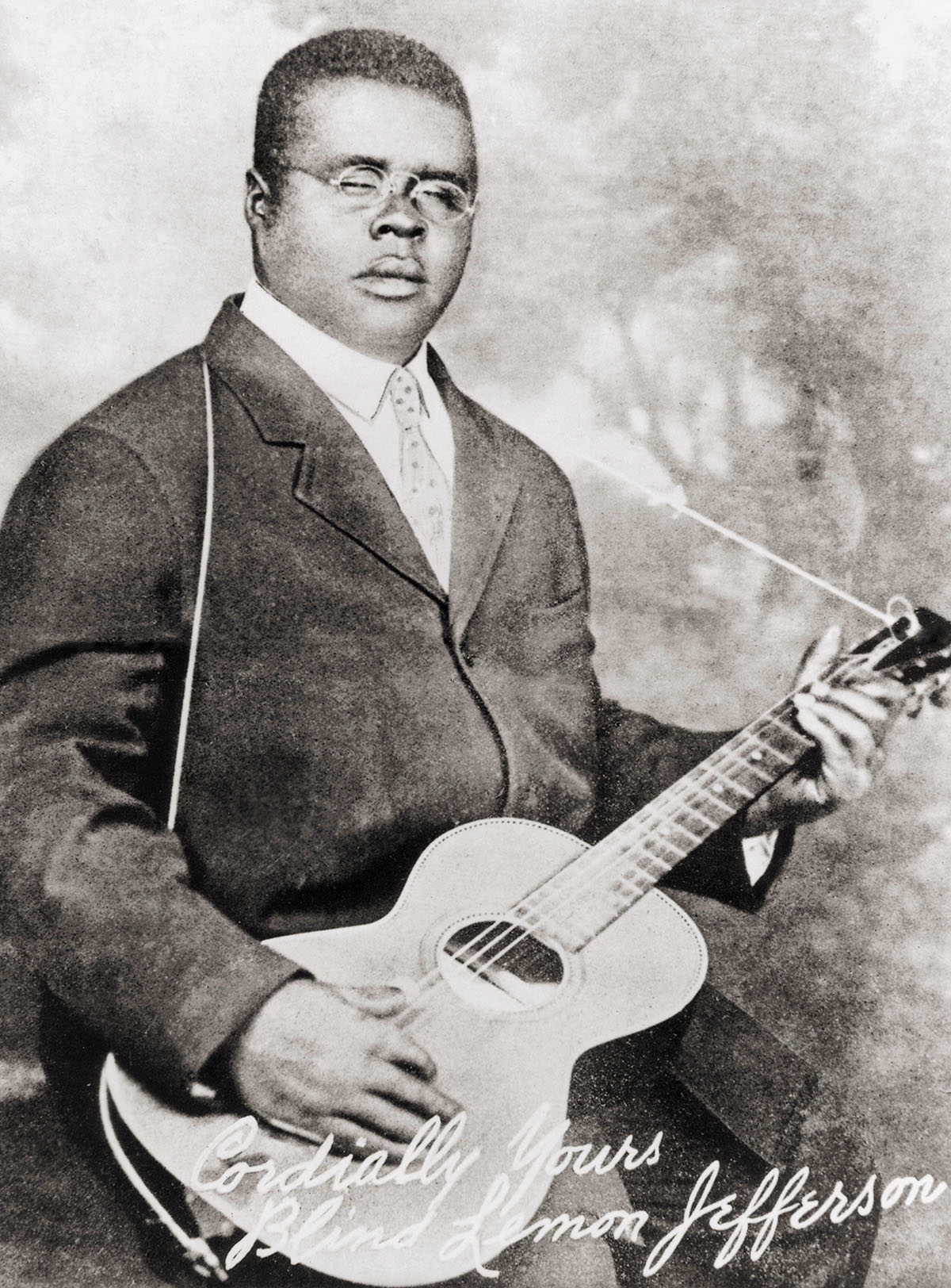 A black and white picture of a man holding a guitar