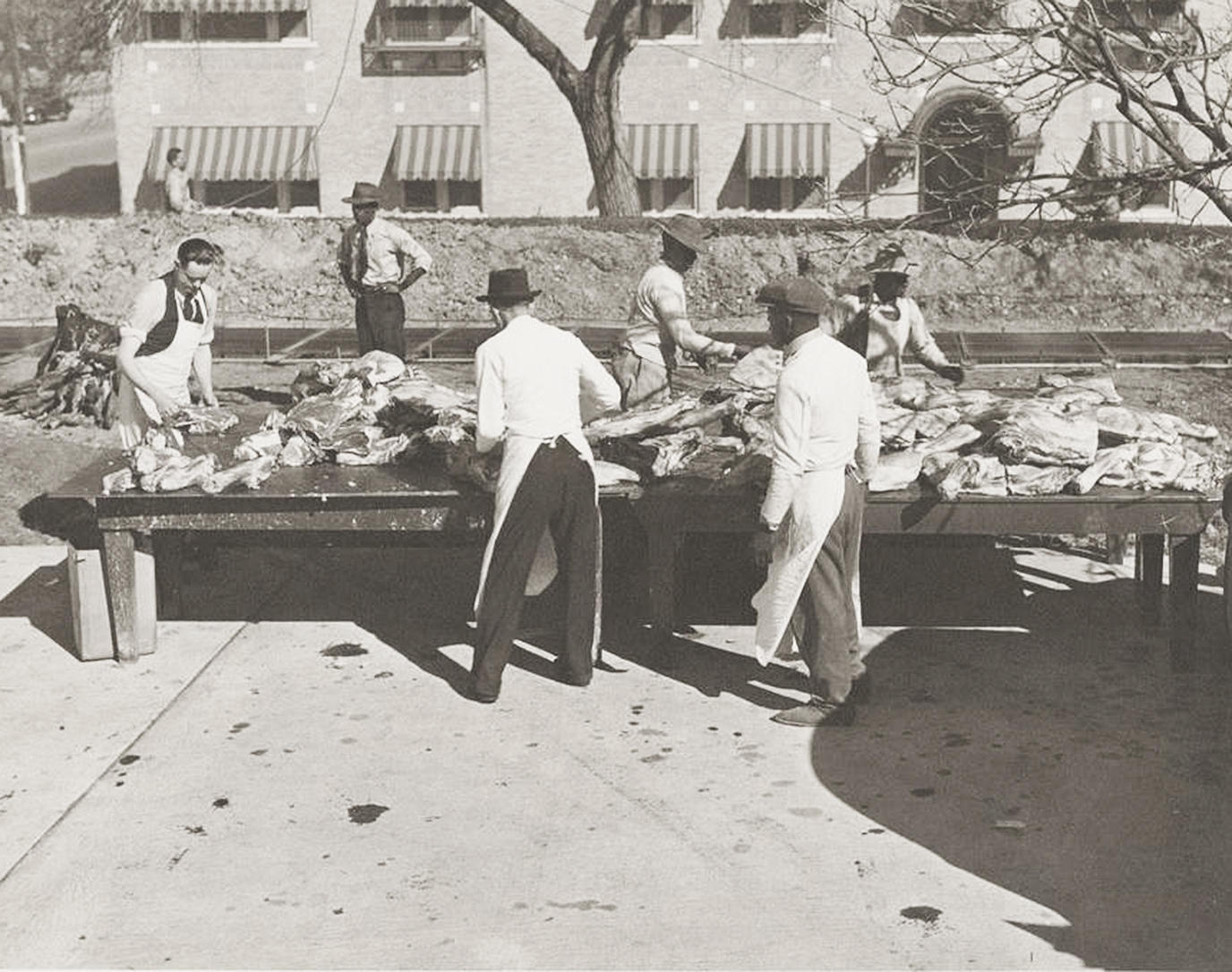 Six people around a barbecue pit in black-and-white