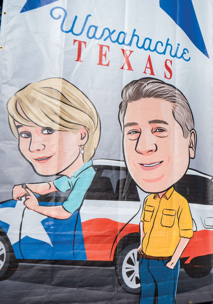 A cartoon drawing of two people in front of a Ford Expedition painted with the Texas flag