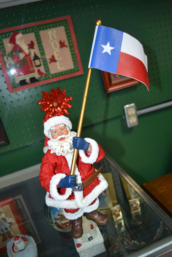 A Santa Claus figurine holds the Texas flag. 