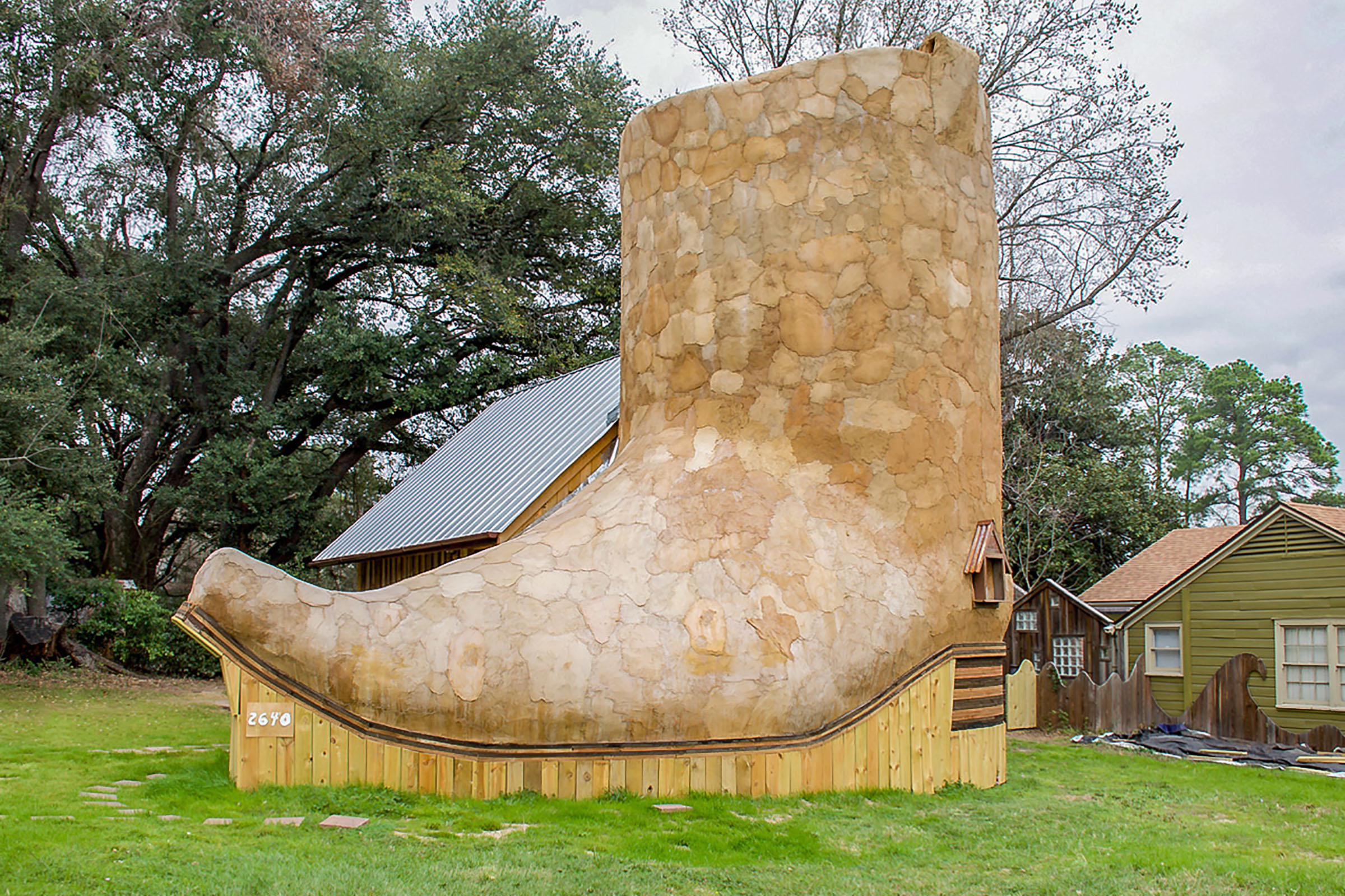 A house made from large tan stones and wood resembling a boot