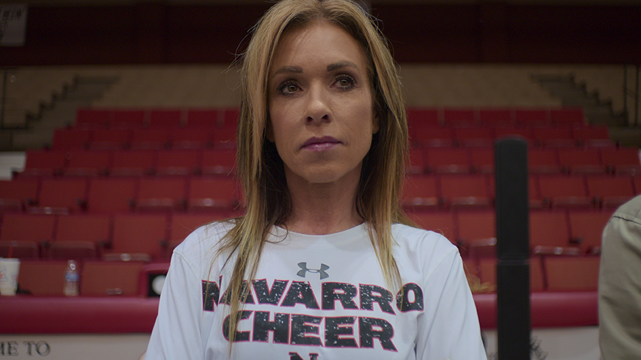 Monica Aldama wears a white Navarro College cheer t-shirt while watching practice.