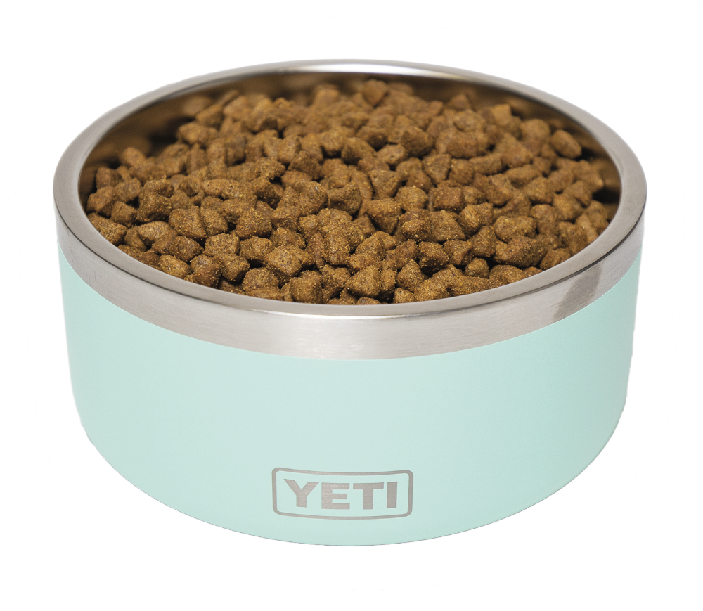 A turquoise, metal bowl reading YETI on the side full of dog food