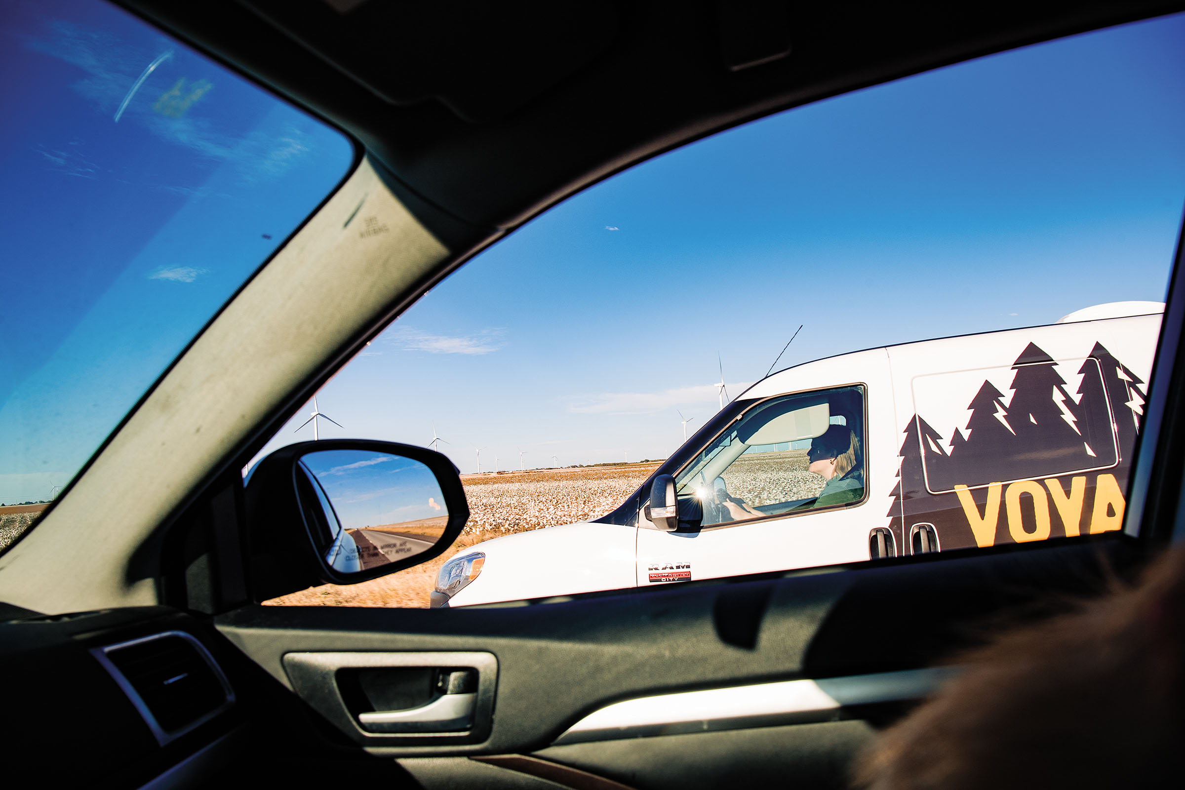 A view of the author's rental campervan through the passenger window of a neighboring car on the open road