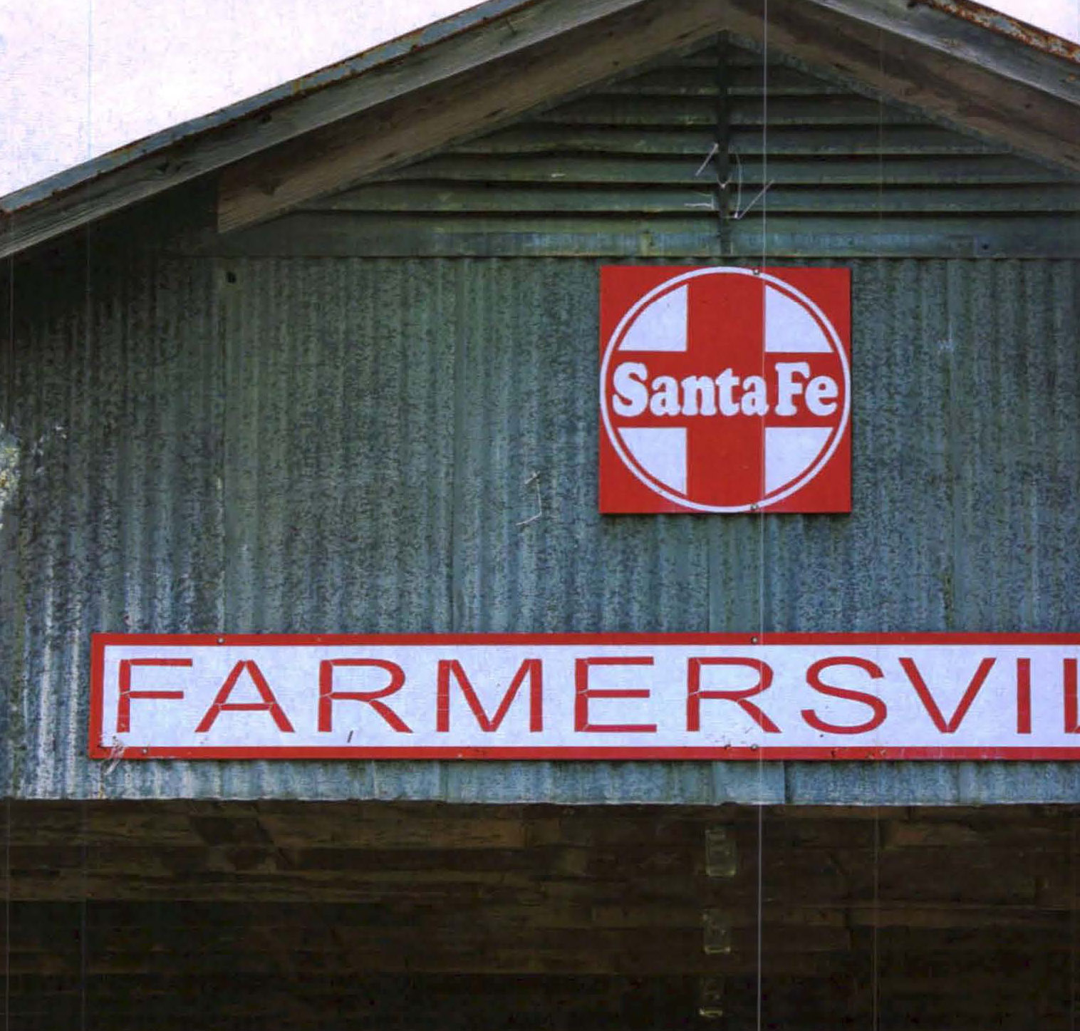 A metal building with a sign reading "Santa Fe Farmersville"