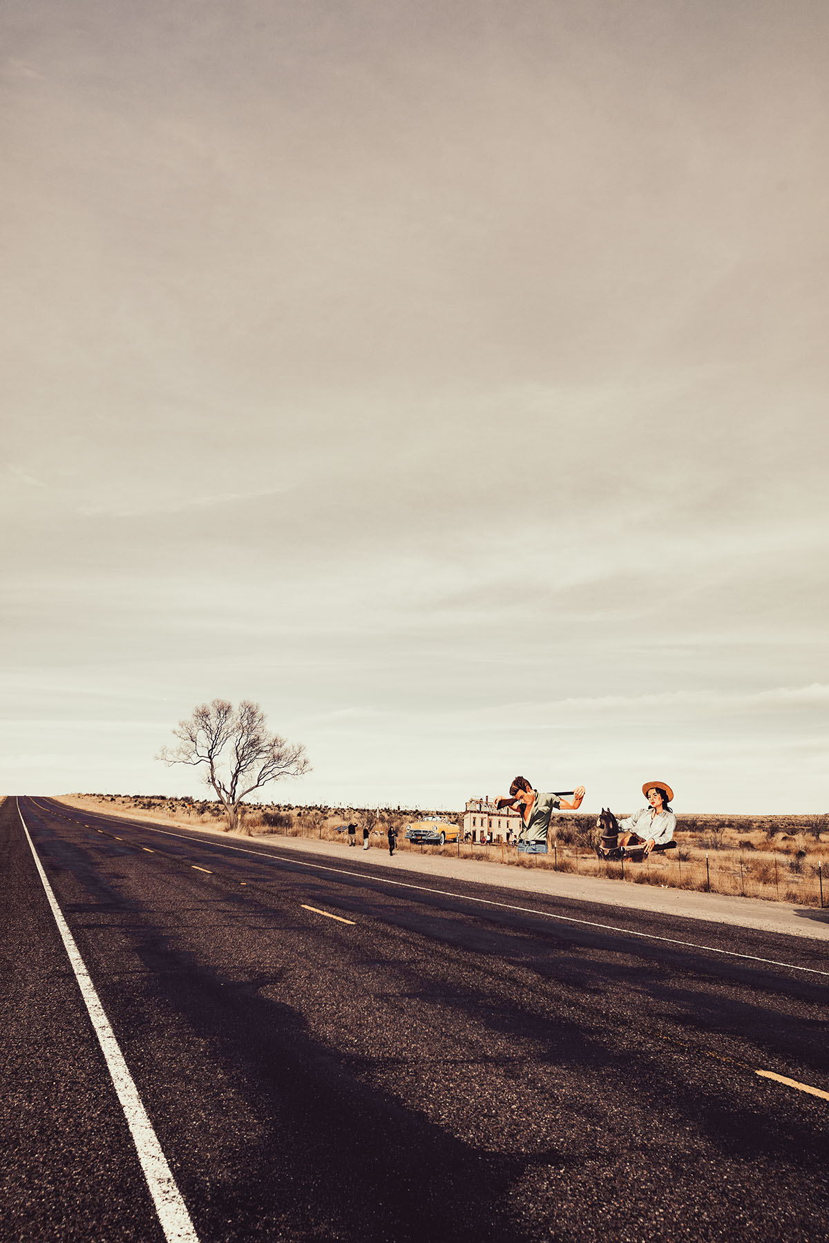 A sepia-tone photo of large cartoon signs along a desert highway