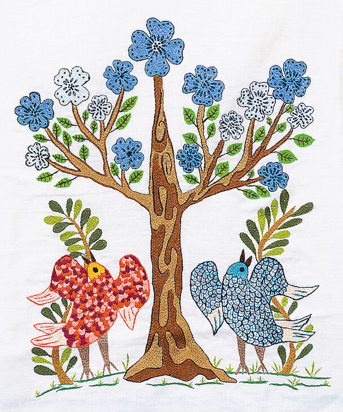 A colorful stitching of blue flowers, green leaves, and a tree atop two birds, one red and one blue