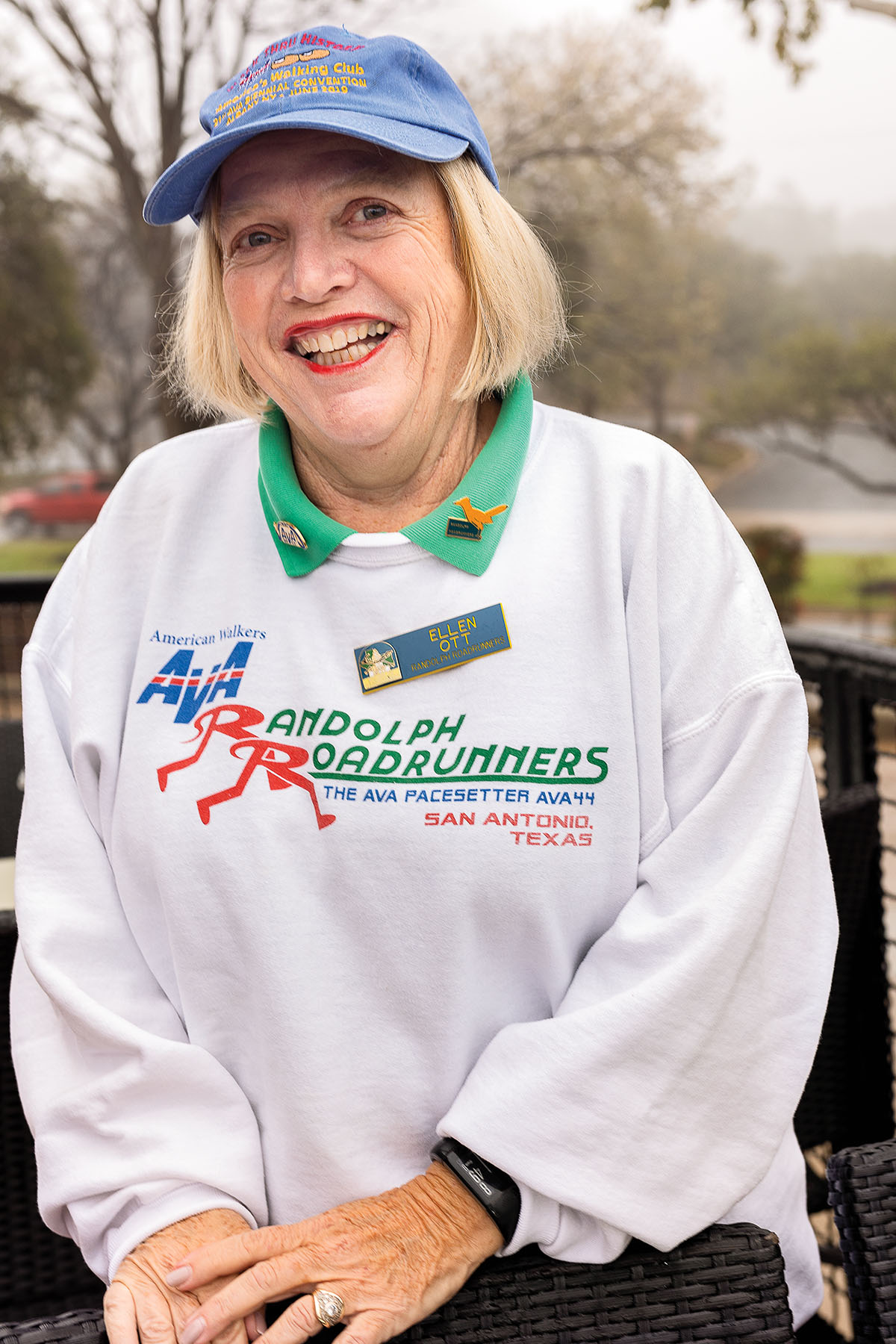 A picture of a woman with short blonde hair wearing a blue baseball cap and a white sweatshirt reading "Randolph Roadrunners"