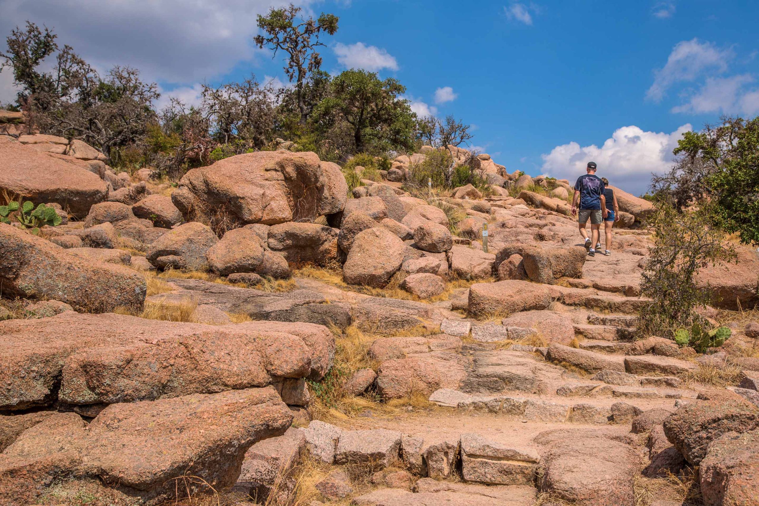 Two hikers climb up a trail at Enchanted Rock in Fredericksburg.