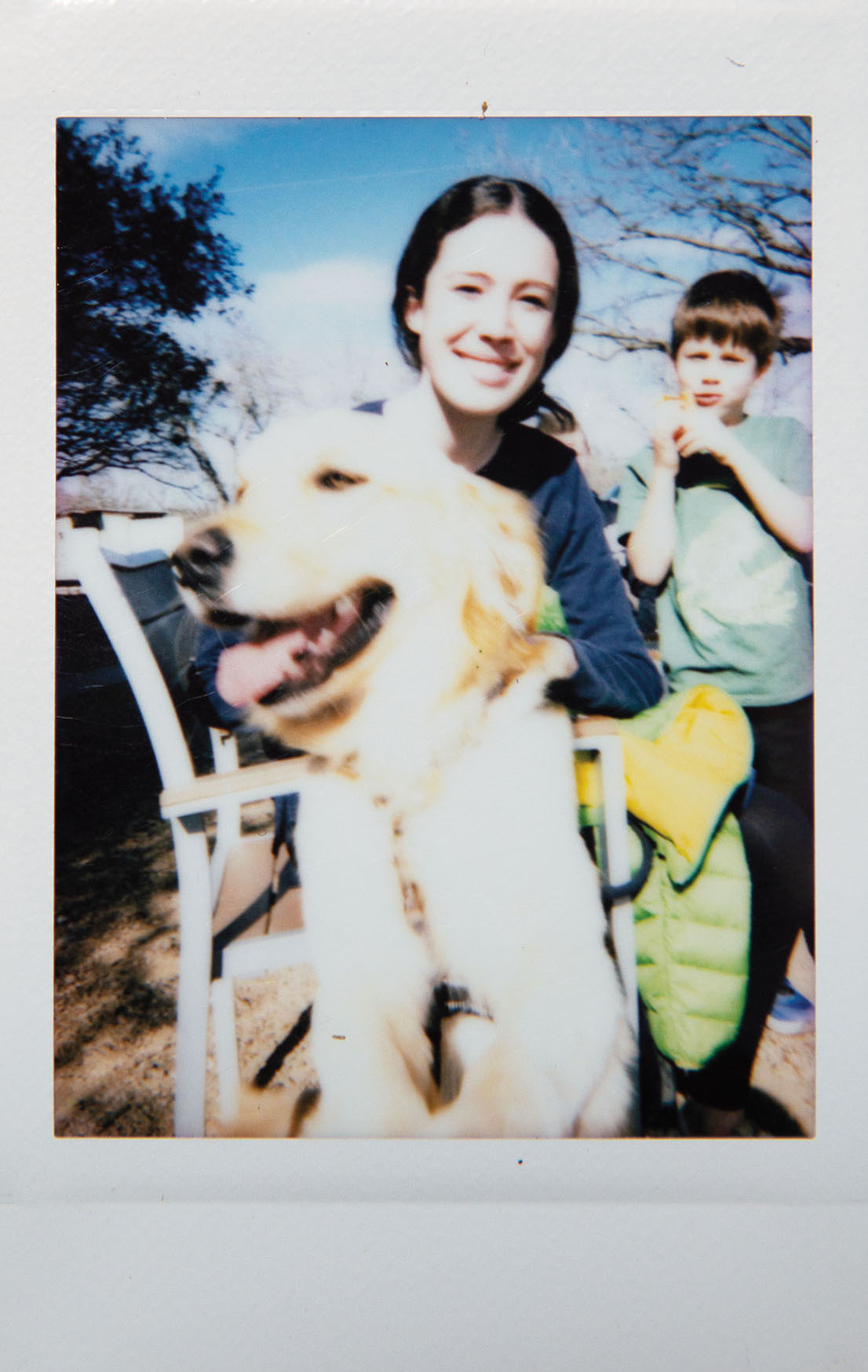 A Polaroid style picture of a young woman and a dog