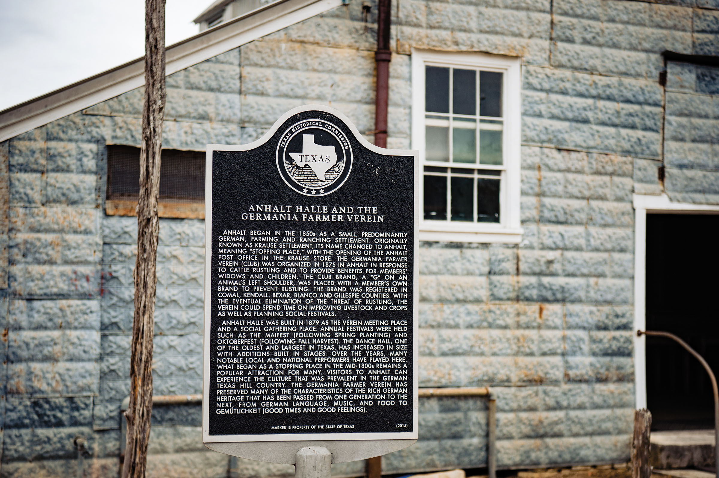 A Texas Historical Marker in front of a stone building
