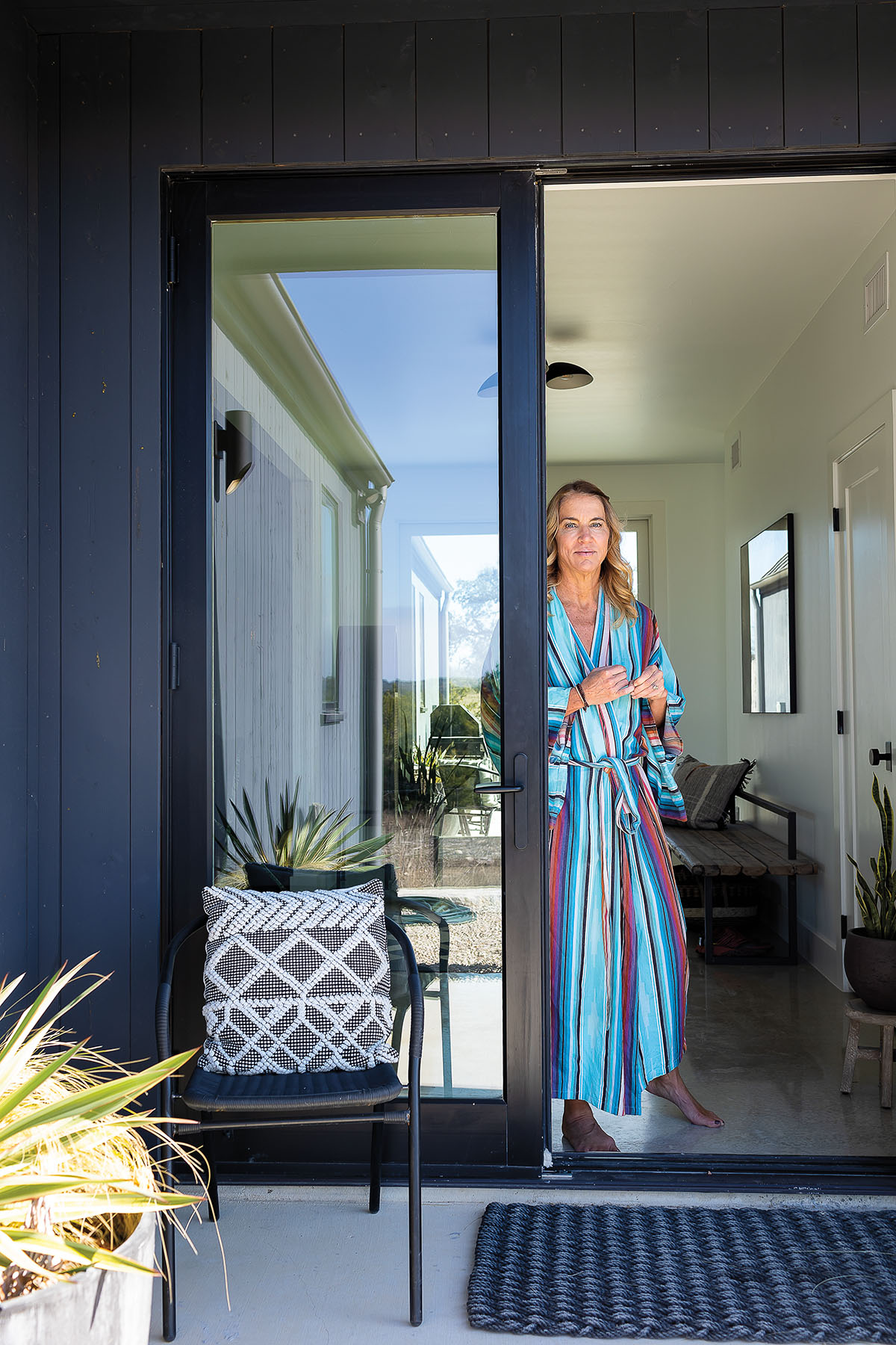 A picture of a woman in a colorful robe standing in an entryway