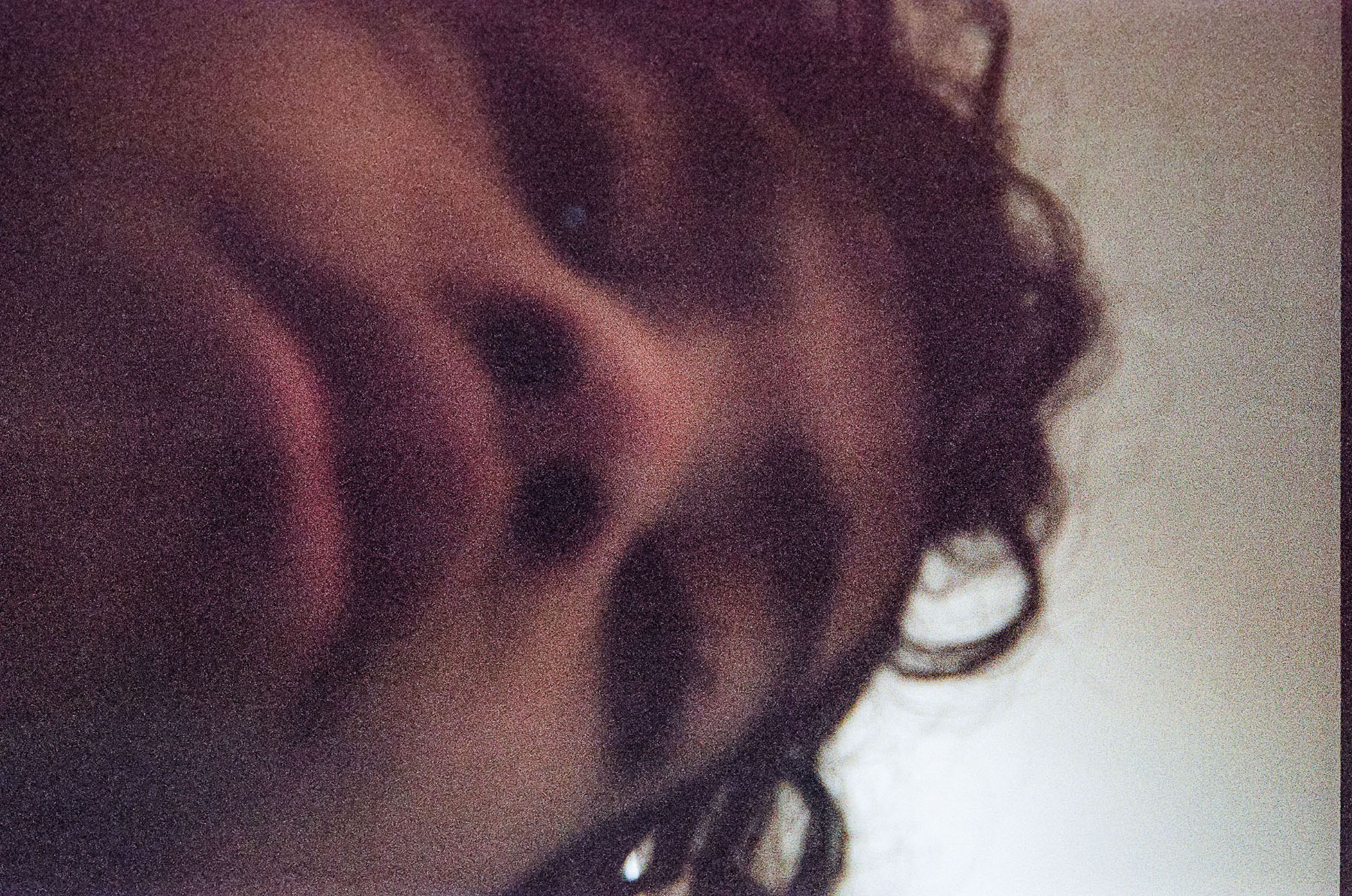 A young man's face fully fills the frame of a selfie image taken from below