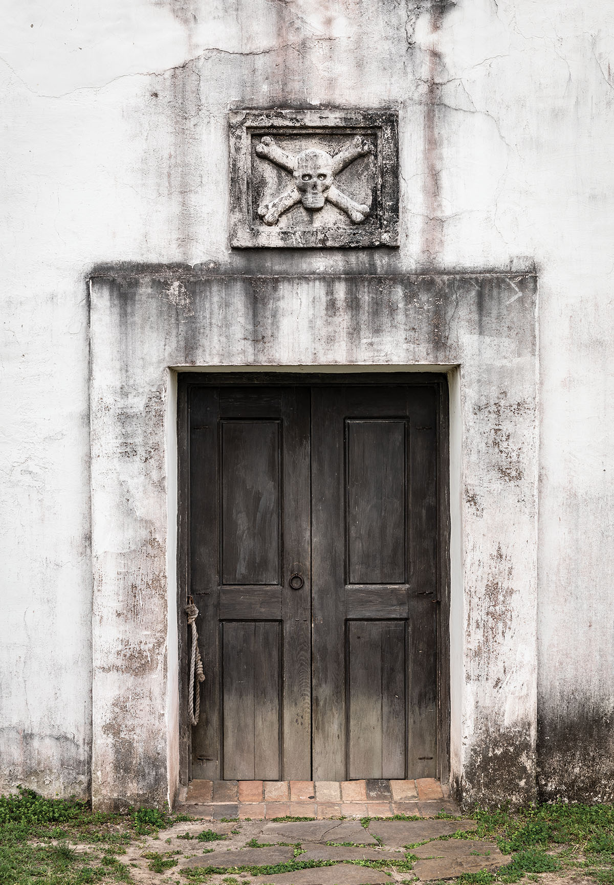 The outside of a stone building with a dark doorway