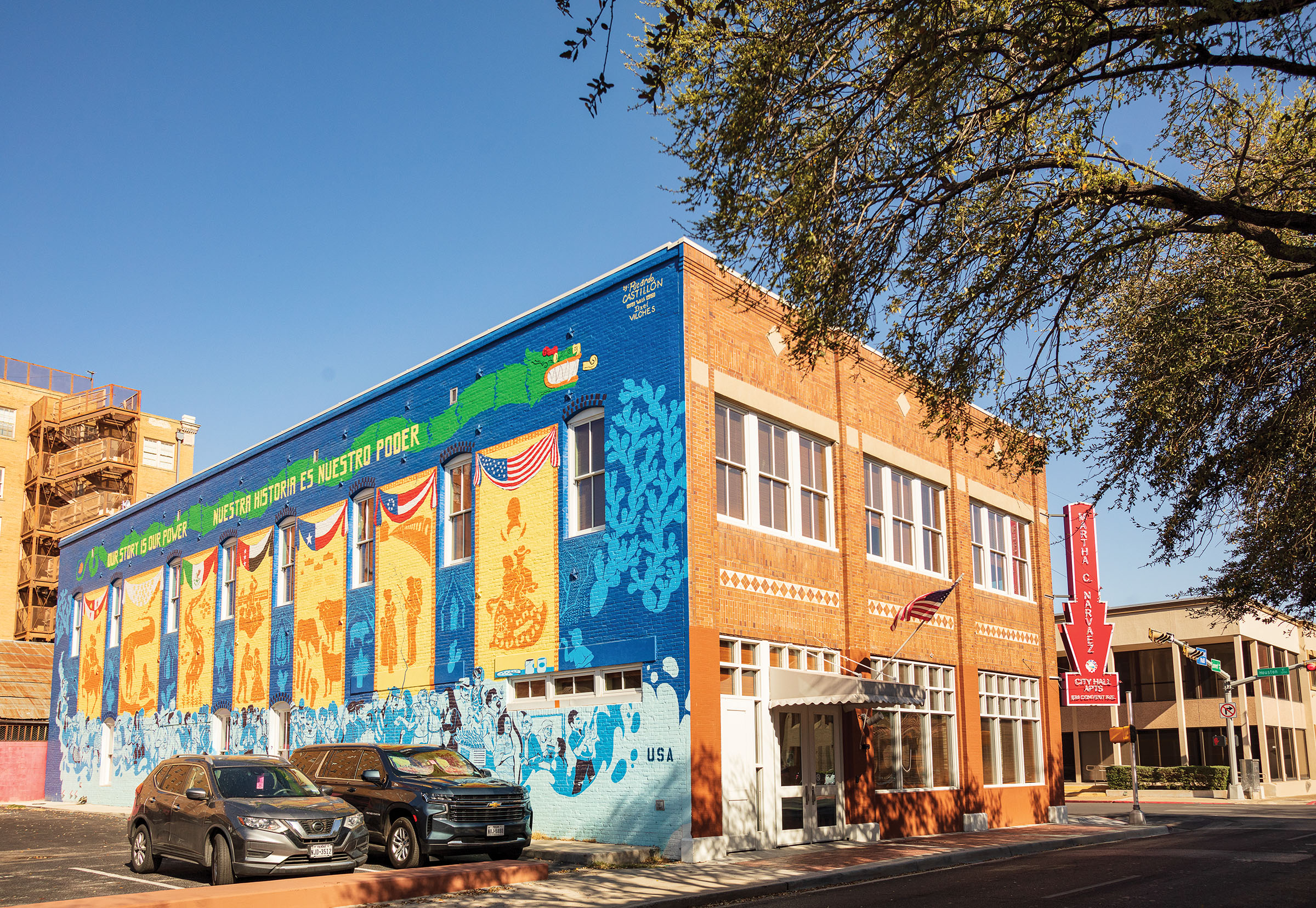 The exterior of a brick building painted with a bright blue and yellow mural
