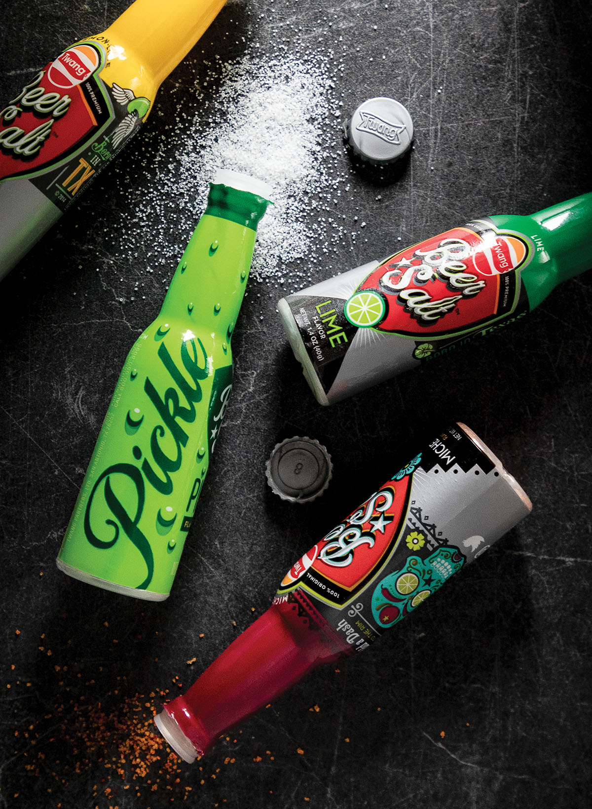 An overhead view of three small bottles of beer salt reading pickle