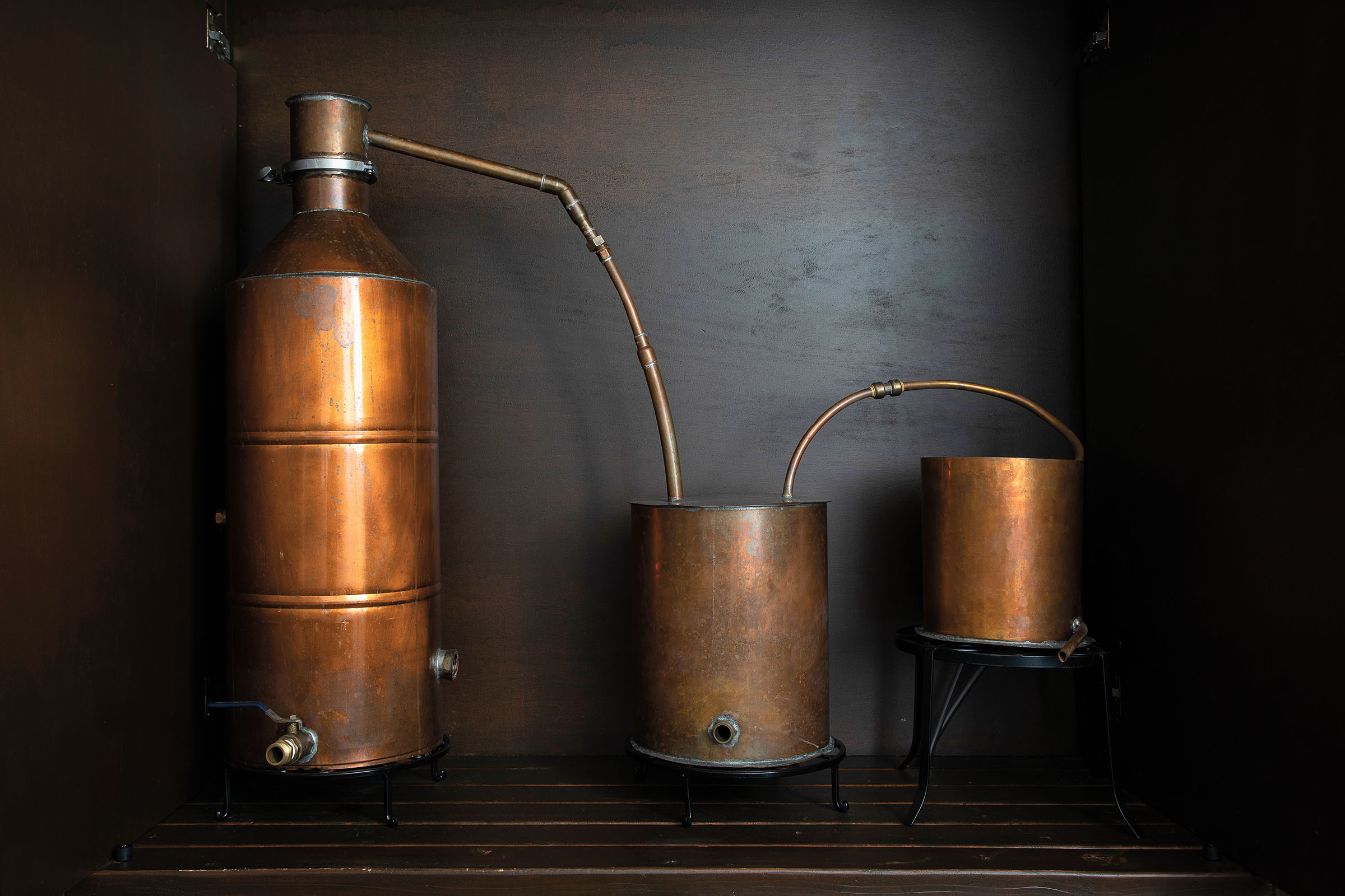 A copper still on a dark background