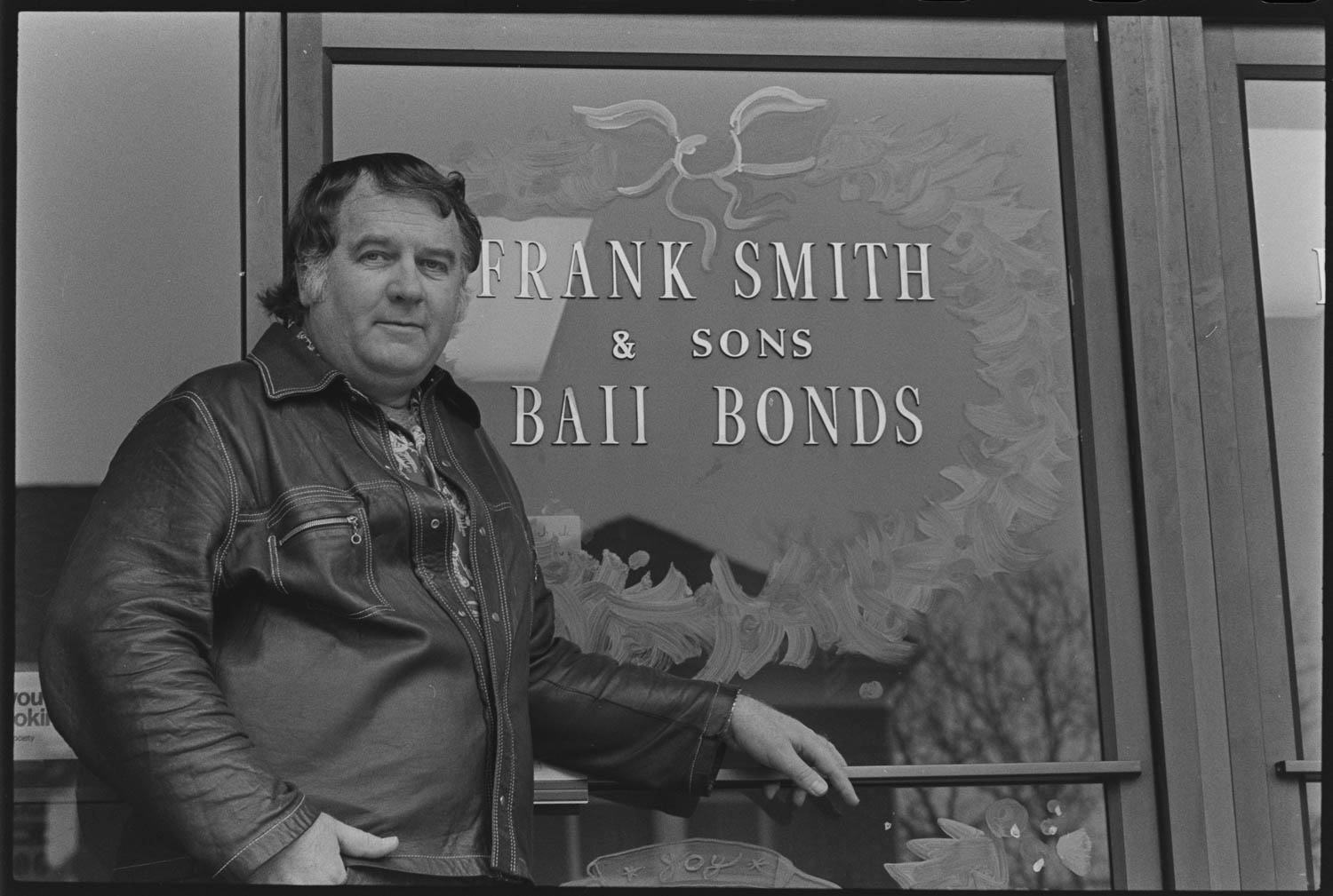 Black and white photo of man in front of bail bond office