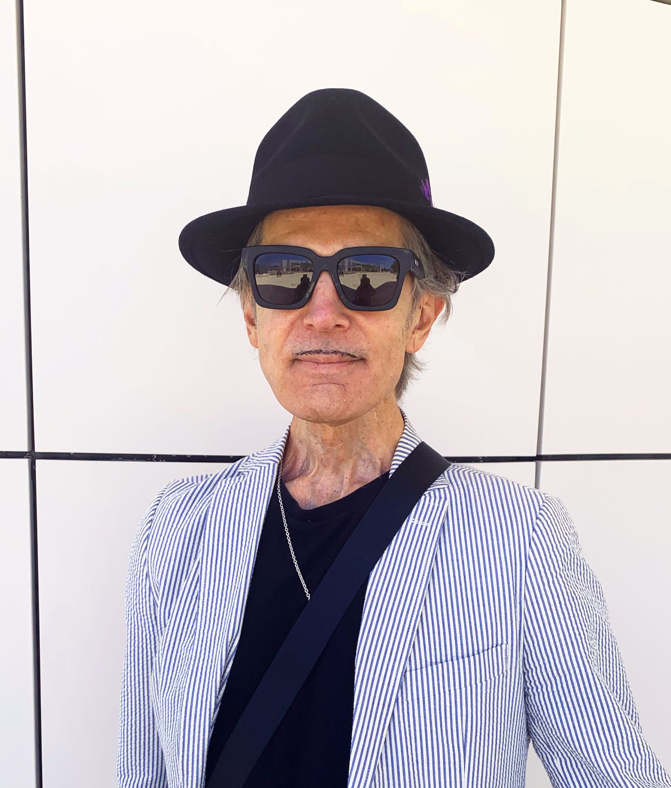 Color photo of man with hat and sunglasses
