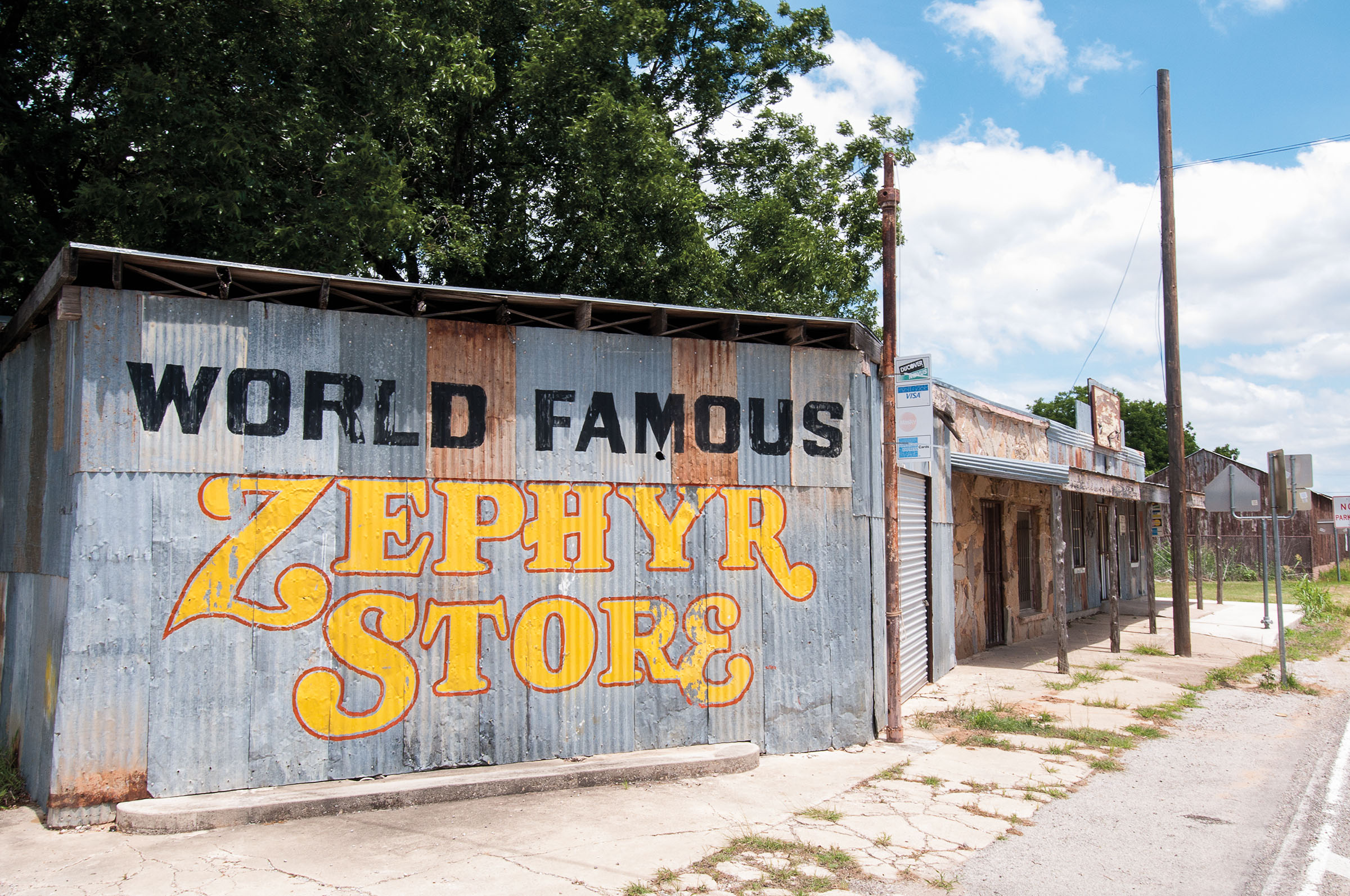 The exterior of a building with metal siding reading "World Famous Zephyr Store"