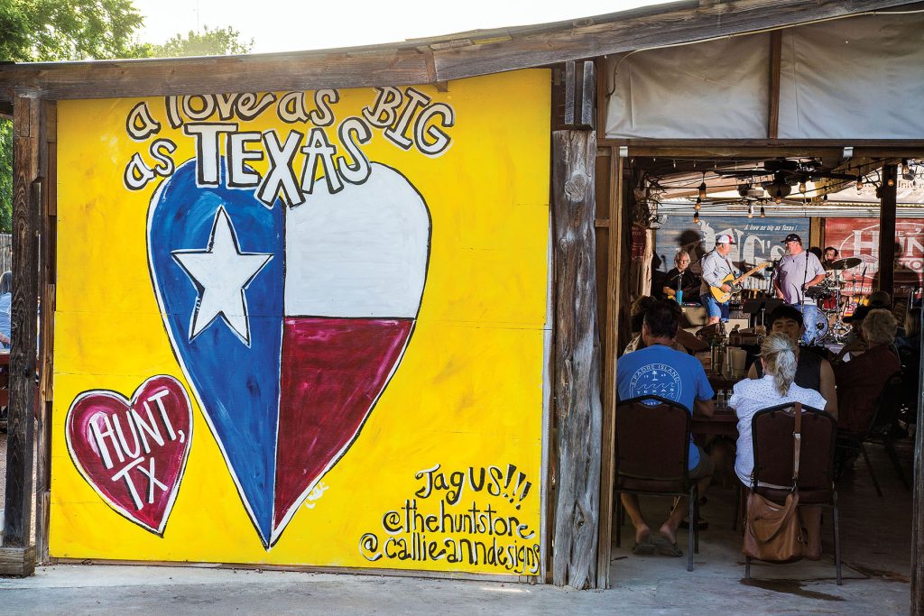 The exterior of a building with a yellow mural reading "Deep in the heart of Texas"