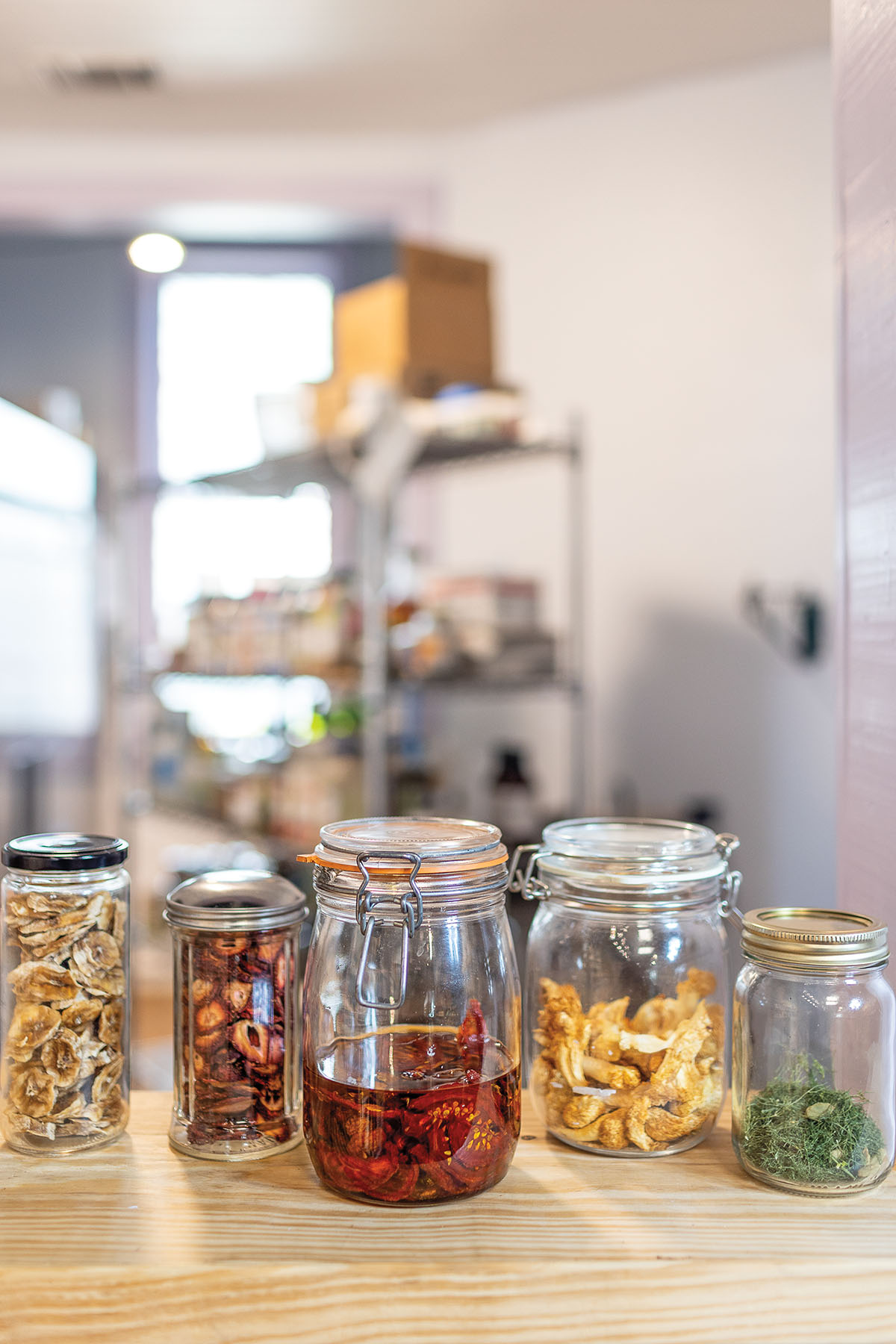 A collection of different brightly-colored foods in sealed glass jars