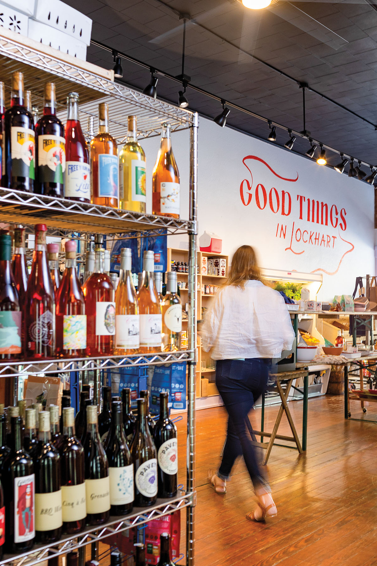 A collection of brightly colored wine on a metal rack in the center of the store