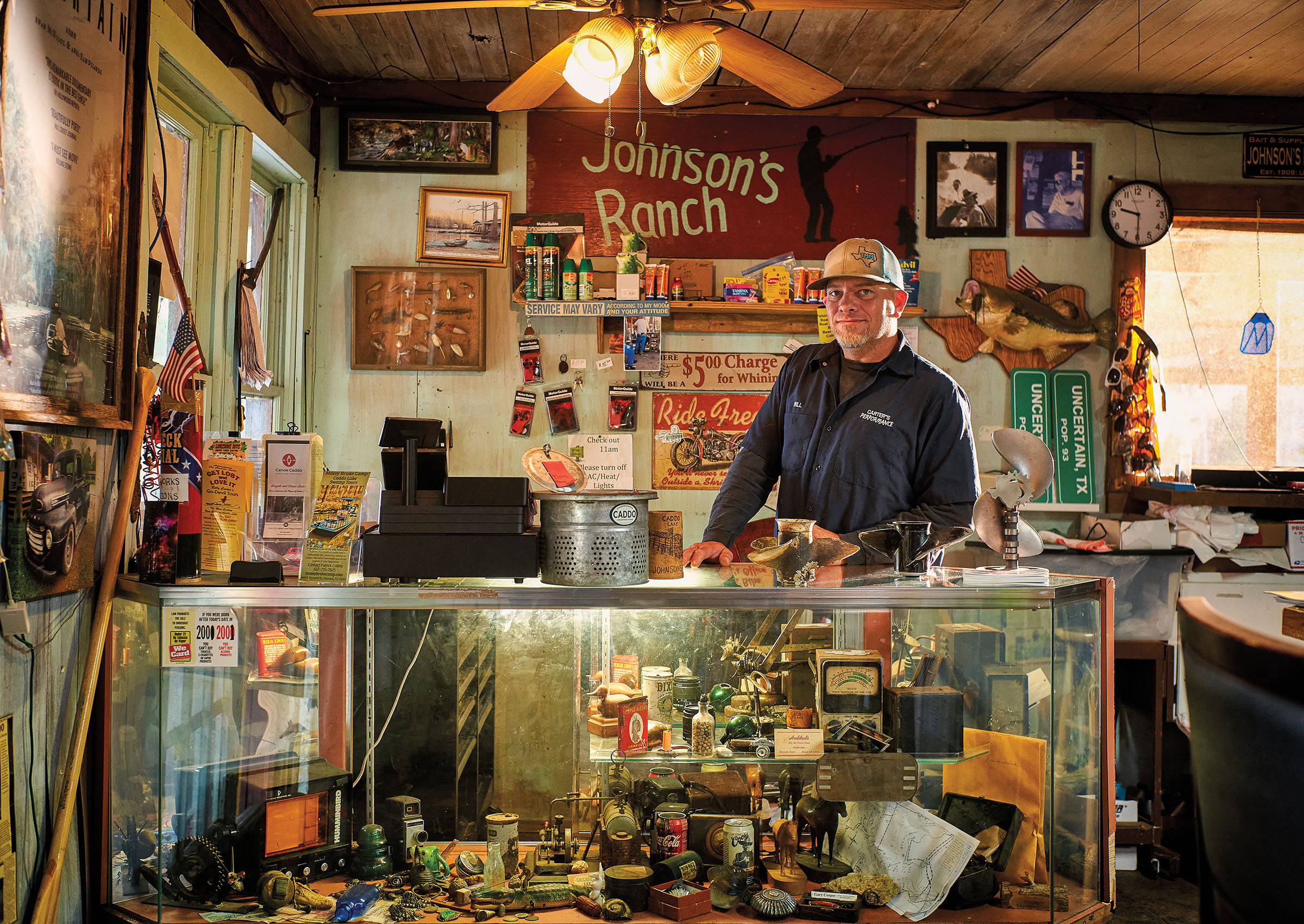 A man stands behind a busy counter in front of a sign reading Johnson's Ranch